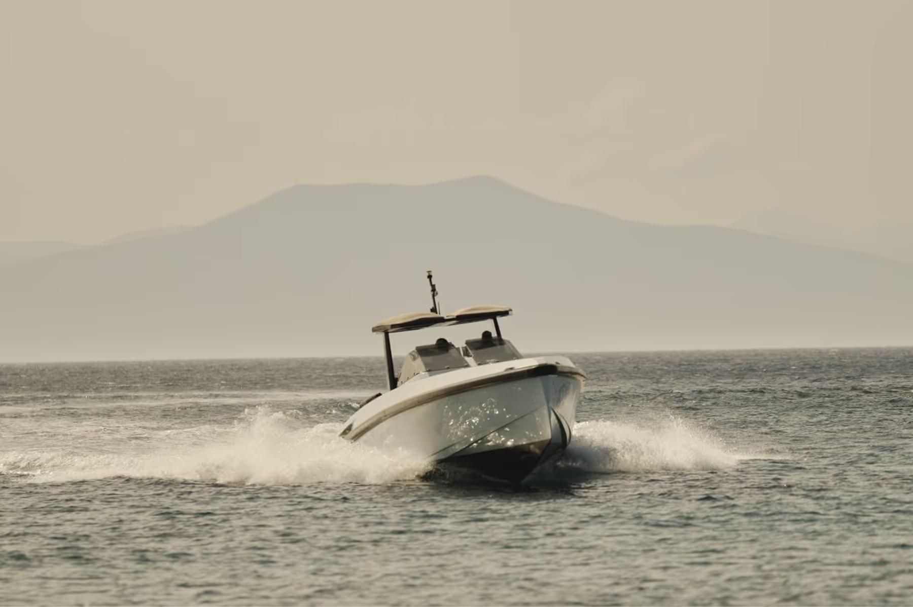 Speedboat on the water with mountain coastline backdrop
