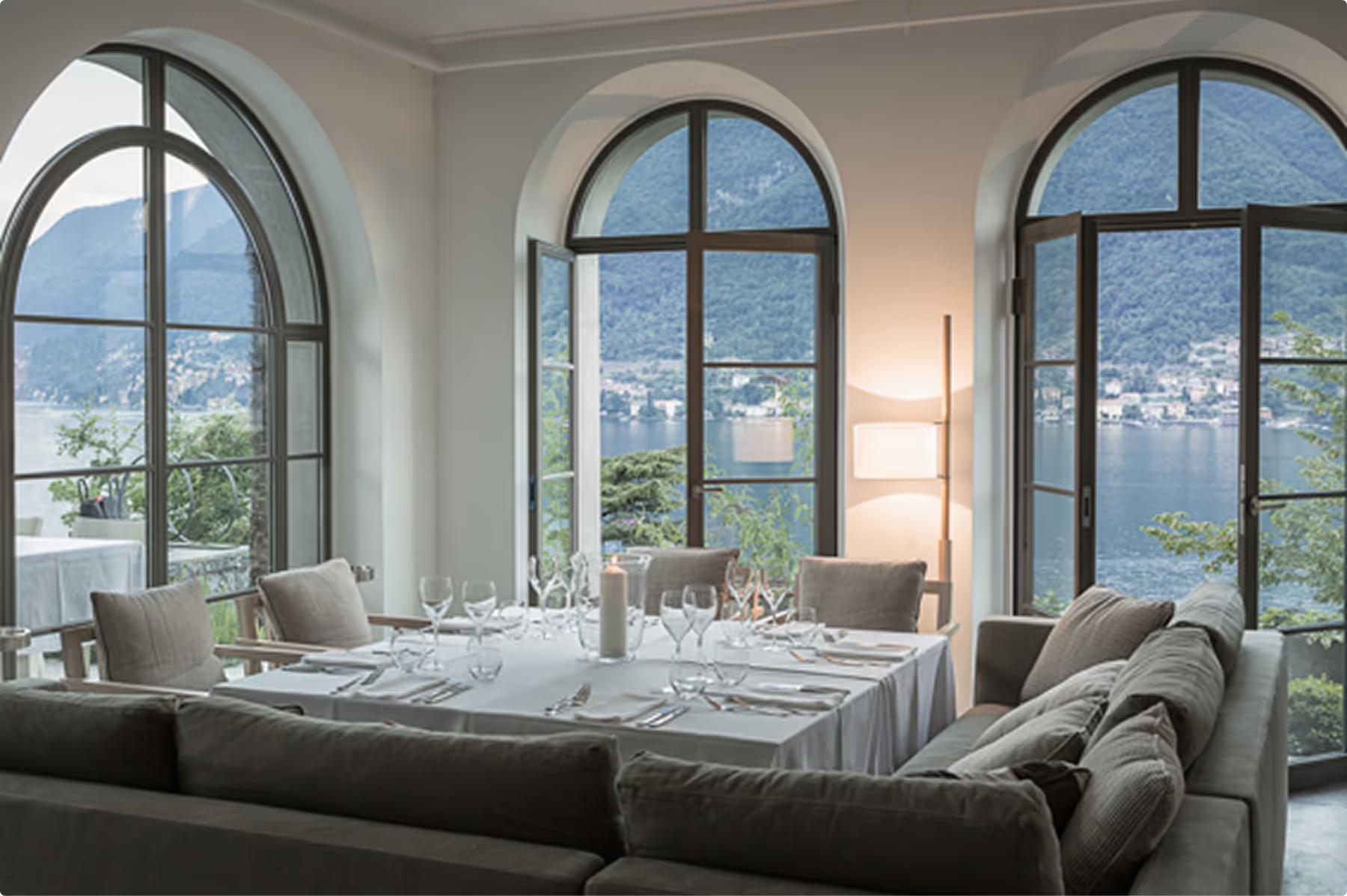Formal dining room with set table and expansive views of the lake and mountains