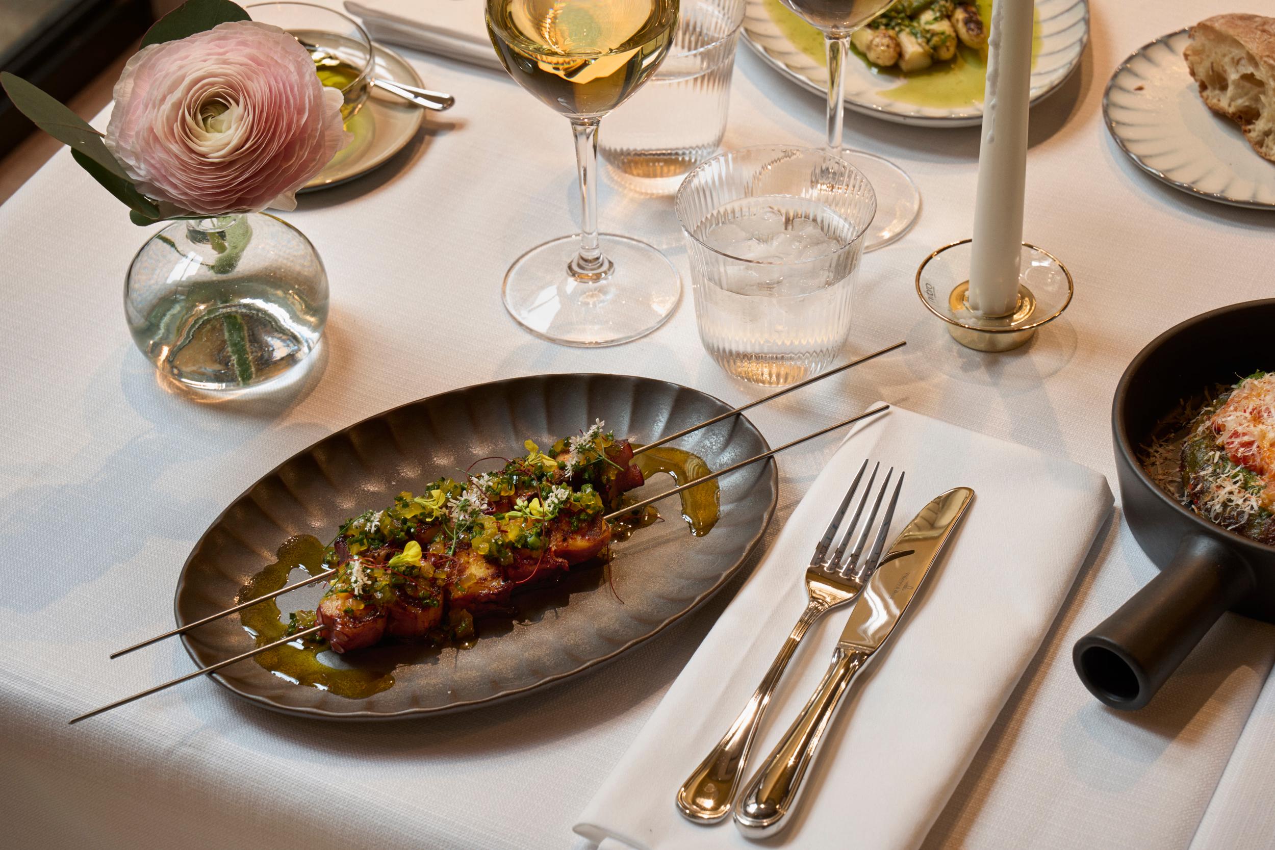 Villa Dagmar: plated dish with seasonal vegetables and delicate garnish paired with wine service
