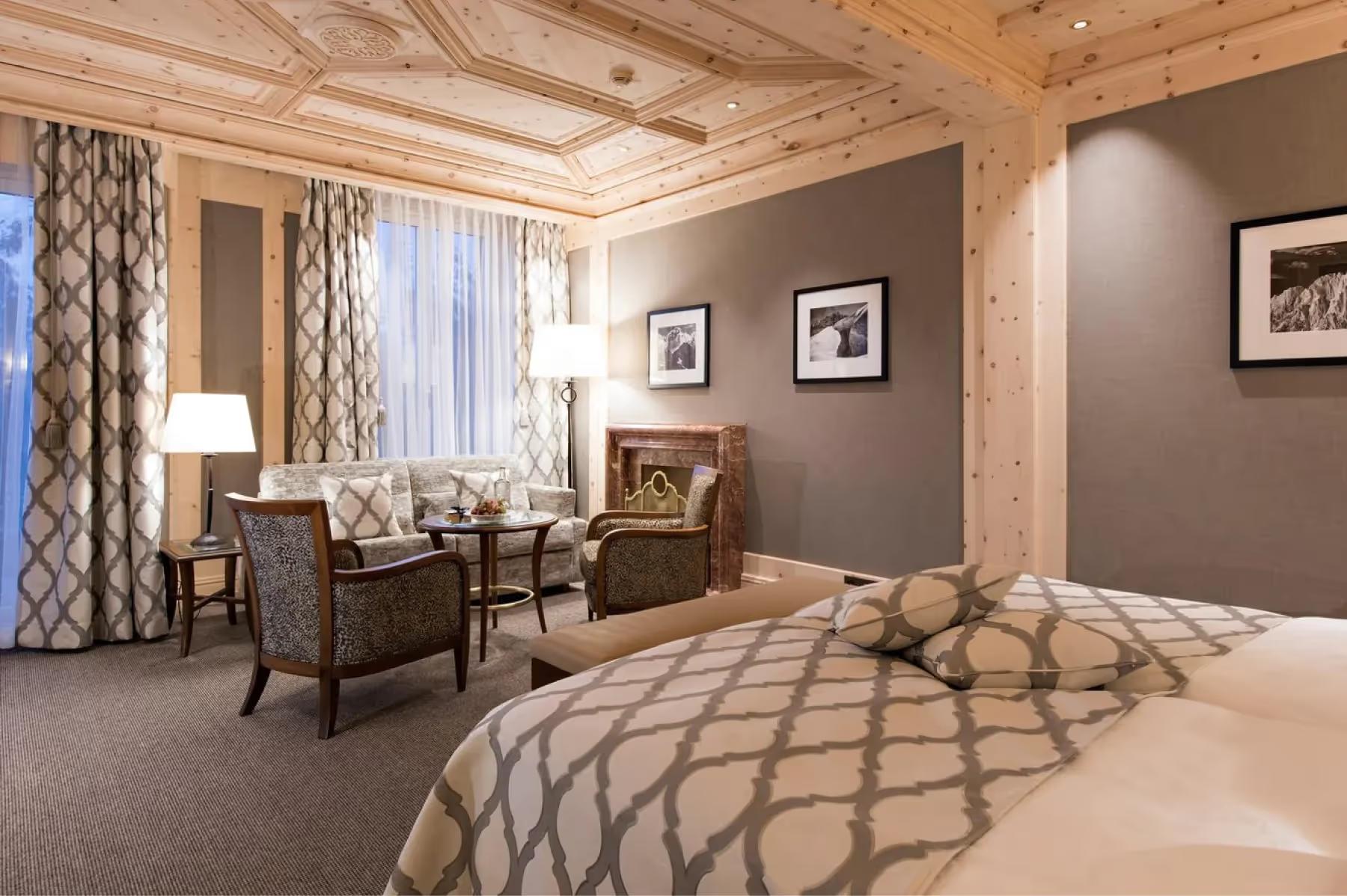 A bedroom with wood-beamed ceiling and contemporary furnishings in neutral tones