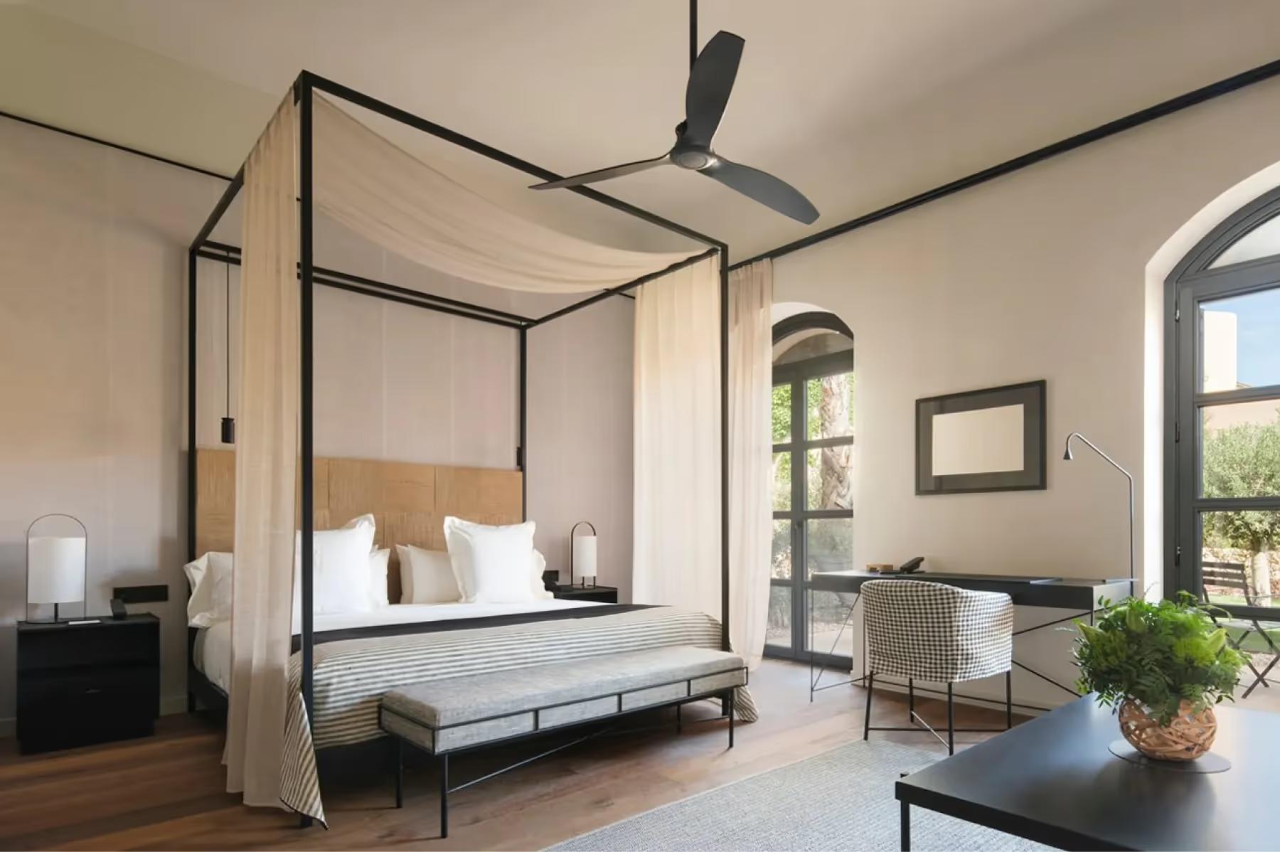 Can Ferrereta: bedroom with four-poster canopy bed, wooden beams, and garden view