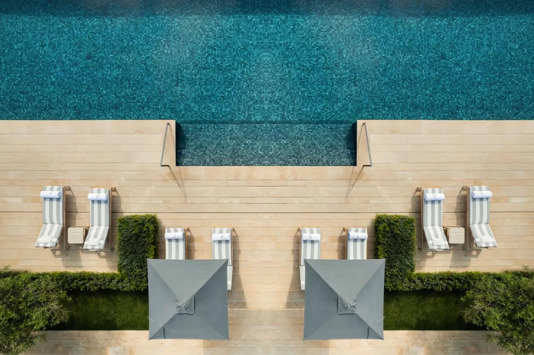 Pool deck with lounge chairs and turquoise water viewed from above