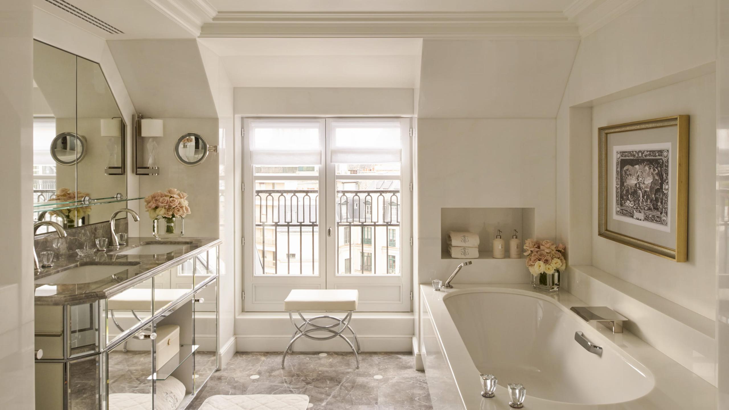 Four Seasons Hotel George V: a marble bathroom with vanity, curved windows framing the city view, and a soaking tub