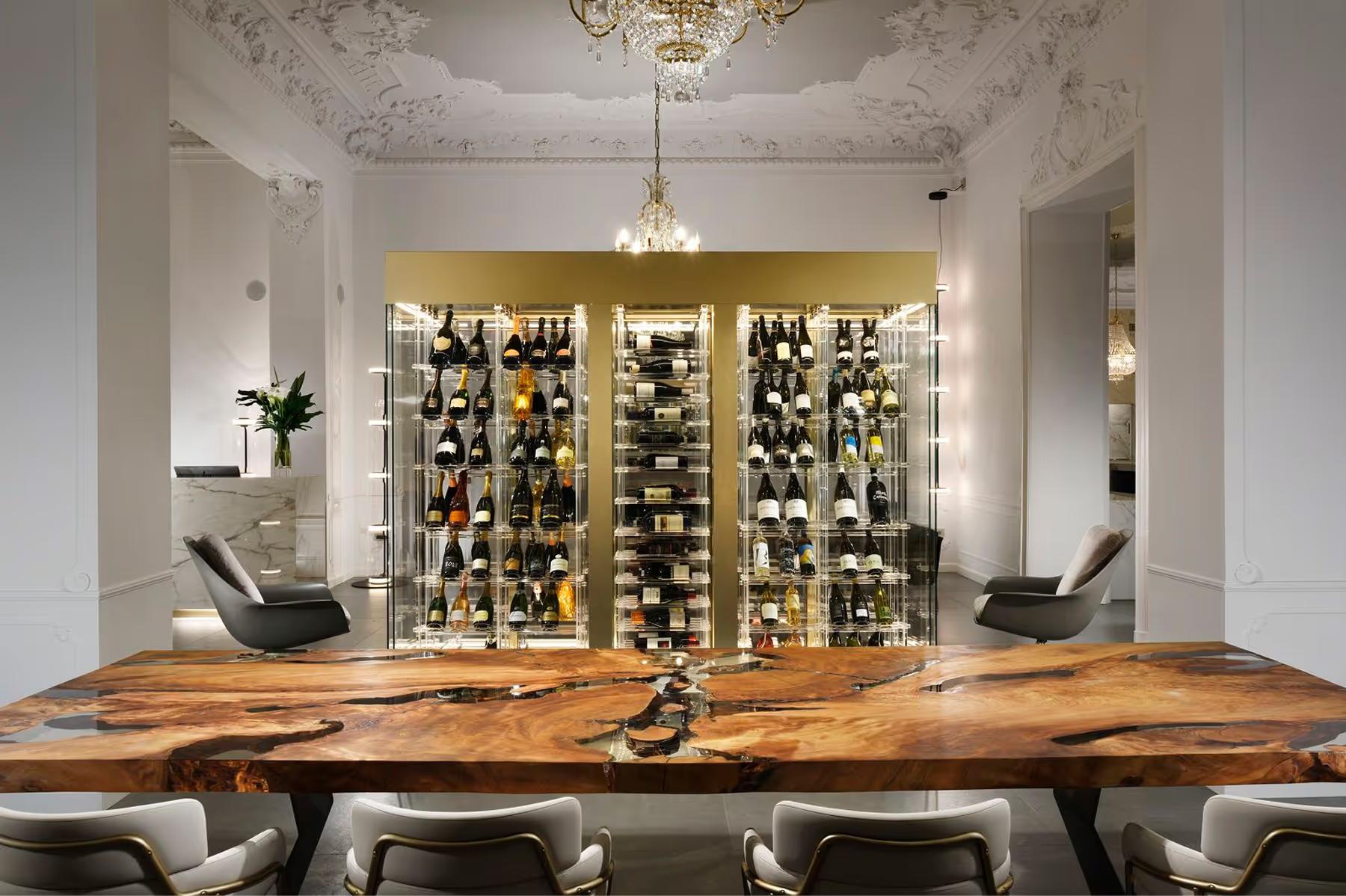 A wine bar interior with a raw wood counter and shelving holding bottles
