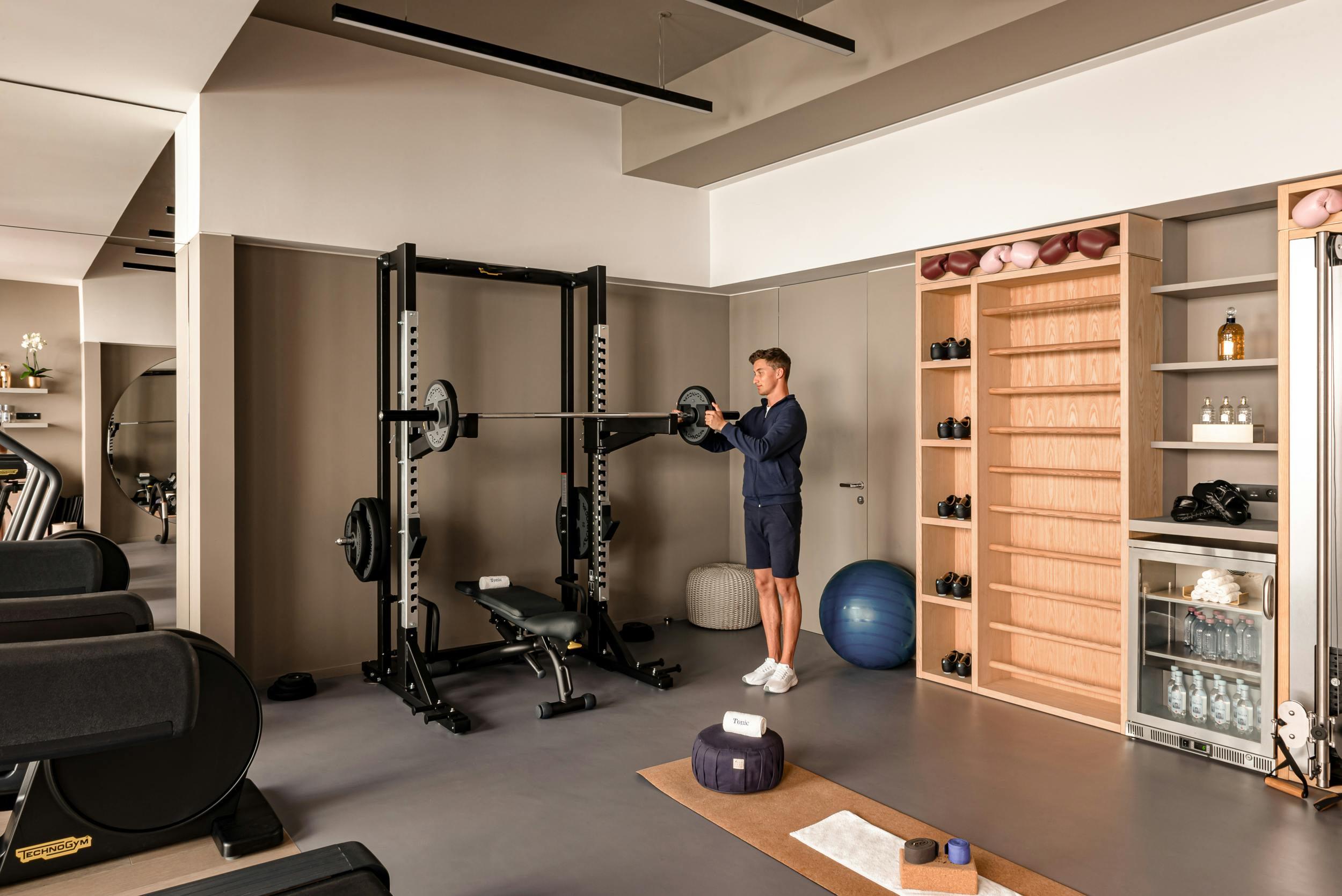 Fitness center with equipment and slotted wood accent wall