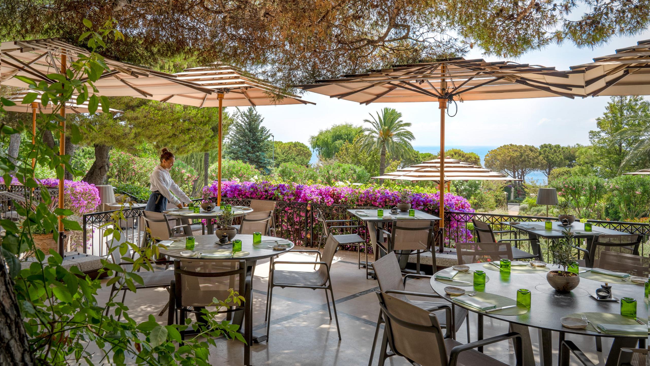Grand-Hôtel du Cap-Ferrat: outdoor terrace with parasols, flowering bougainvillea, and garden seating