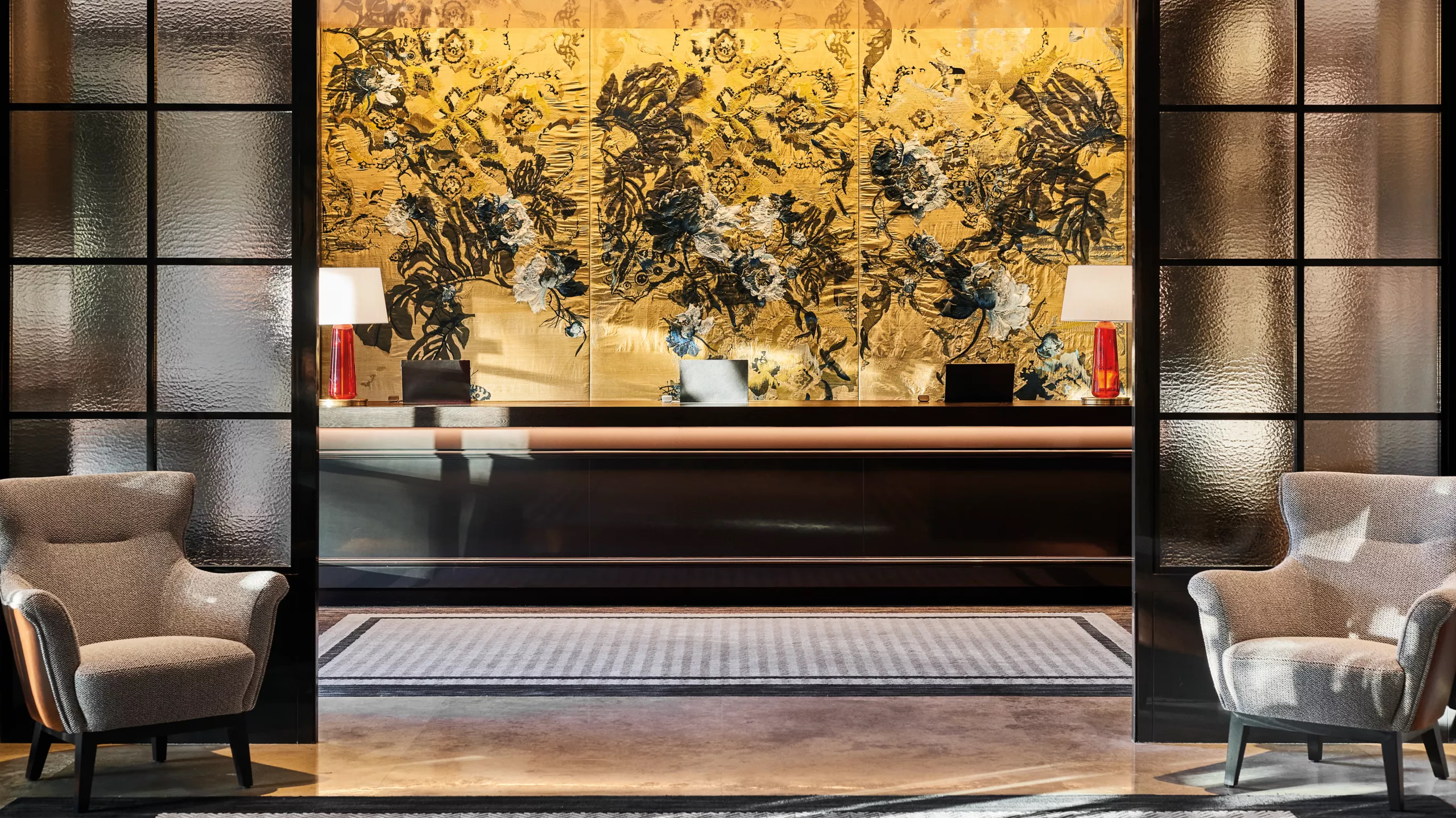 A lobby focal point with gold leaf artwork, sculptural black element, and seating areas