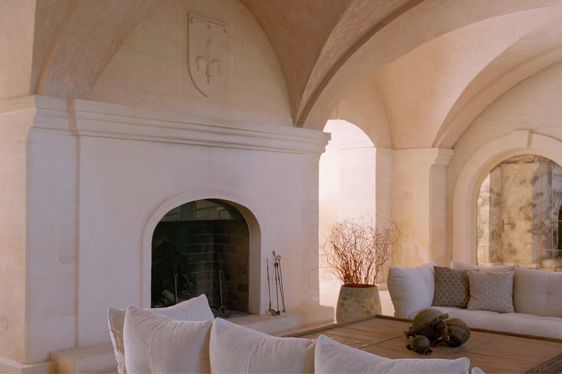 Modern interior with barrel vaults, arched doorway, and understated seating arrangements
