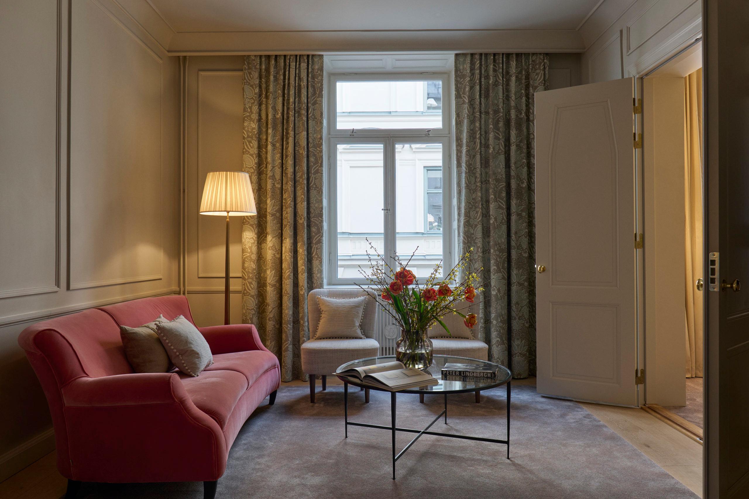 Villa Dagmar: suite with burgundy seating, city views, and separation between sleeping and living areas