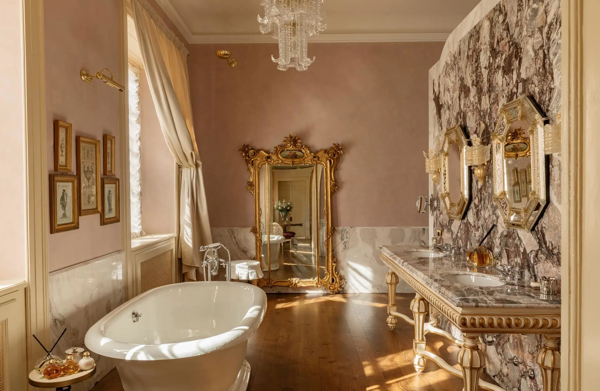 A bathroom with pink walls, freestanding soaking tub, and ornate marble details