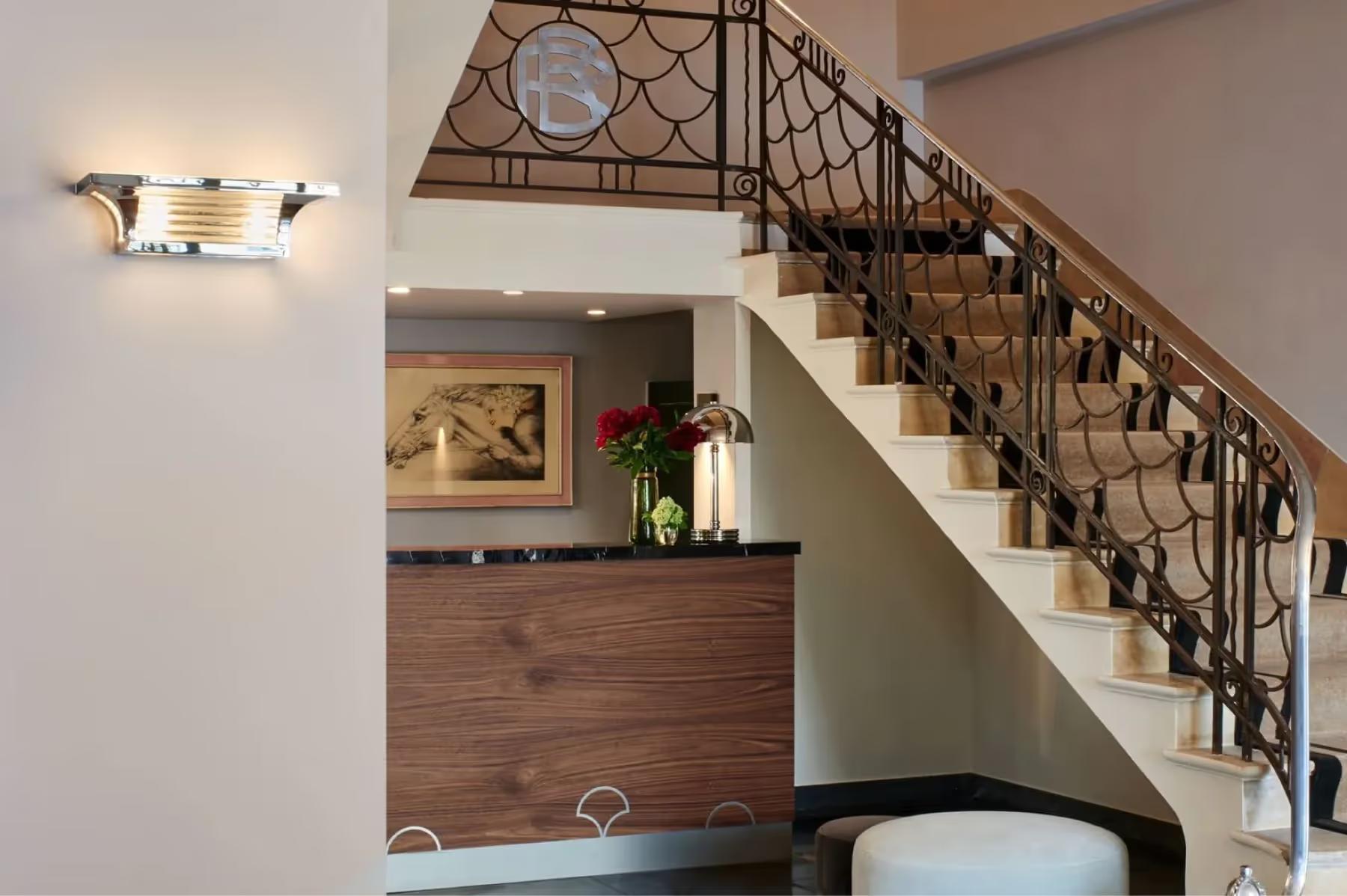 Les Roches Blanches: a guest room with modern elements, double-height interior, and metal staircase to upper level