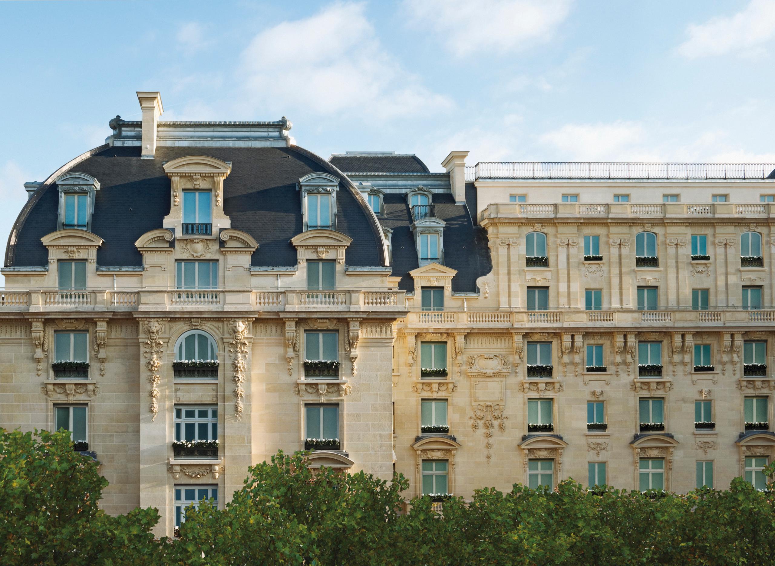 The Peninsula: mansard roofs and neoclassical stonework of a Haussmannian facade under bright daylight