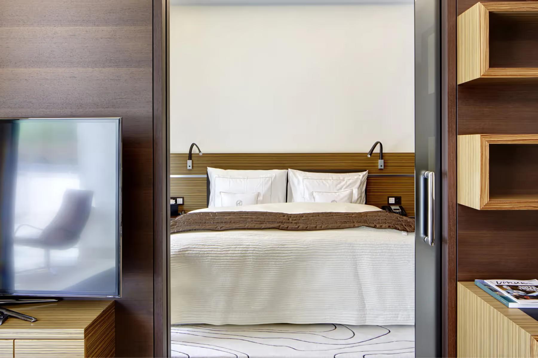 Park Hotel Vitznau: modern bedroom with beige bedding and warm wood tones