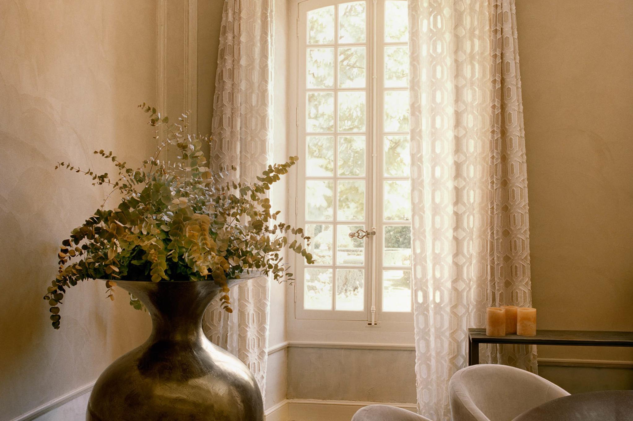 Le Mas de Chabran: flowers in terracotta vase on windowsill with white gauze curtains and bright daylight