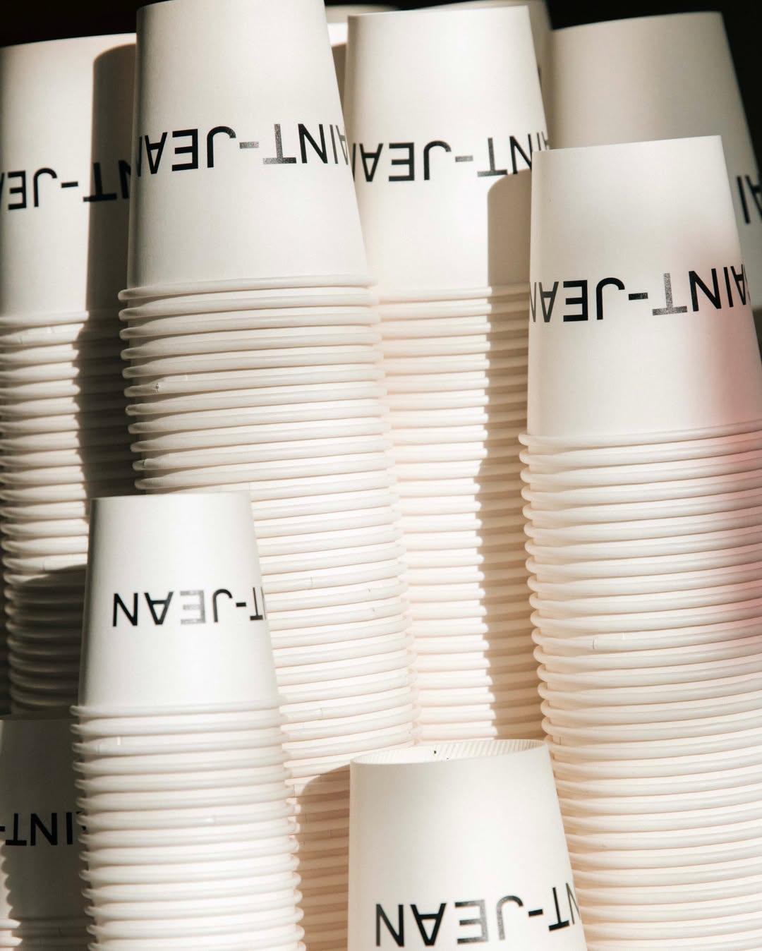 Stacked Saint-Jean takeaway cups in afternoon light