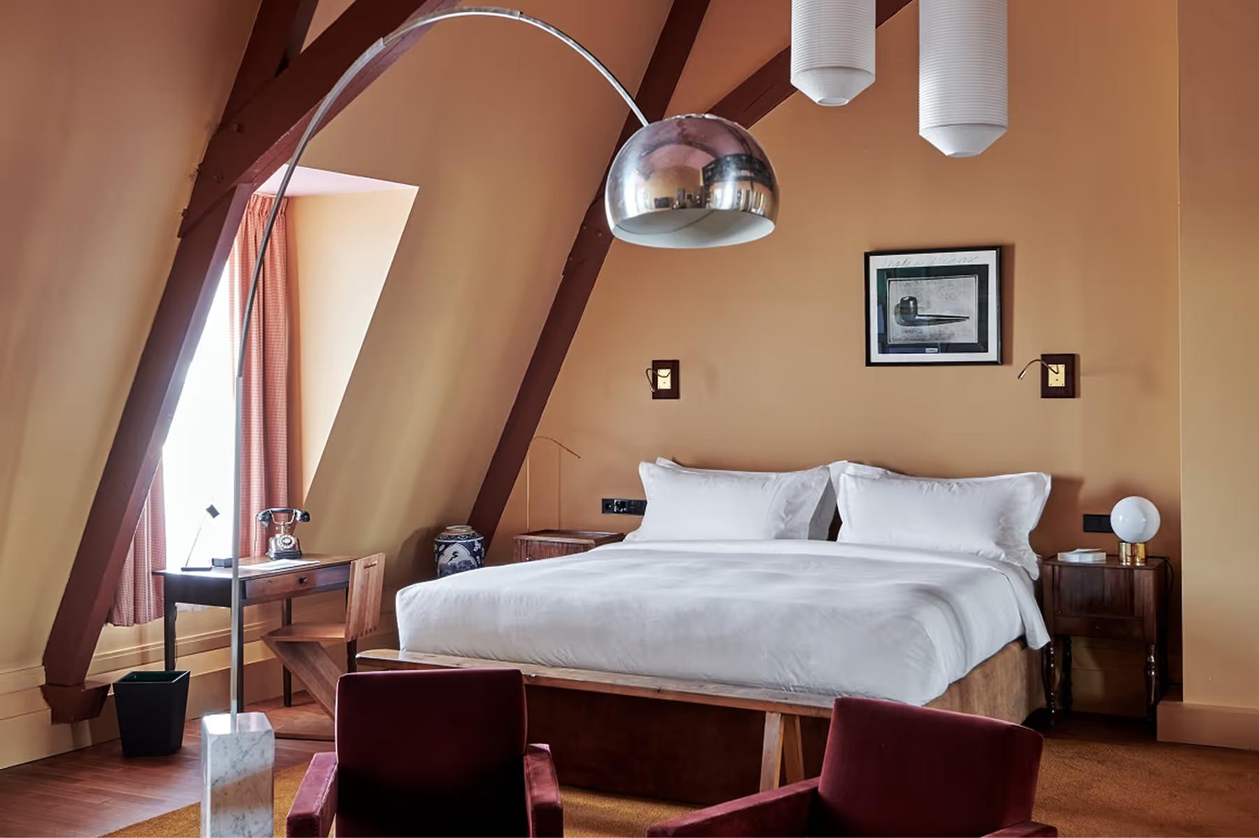 Attic bedroom with sloped ceiling, arched window detail, and compact layout