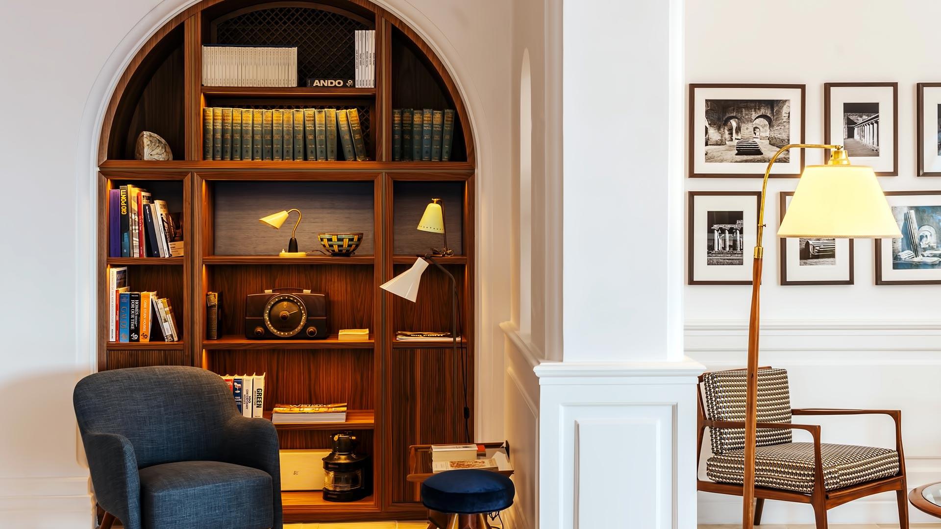 Borgo Santandrea: library nook with arched wooden shelving filled with books and decorative objects