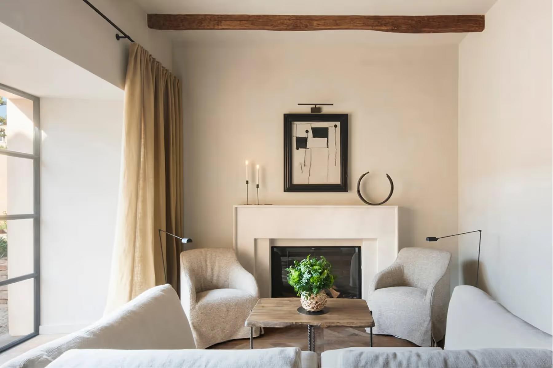 Can Ferrereta: living room seating area with fireplace and wooden ceiling beams
