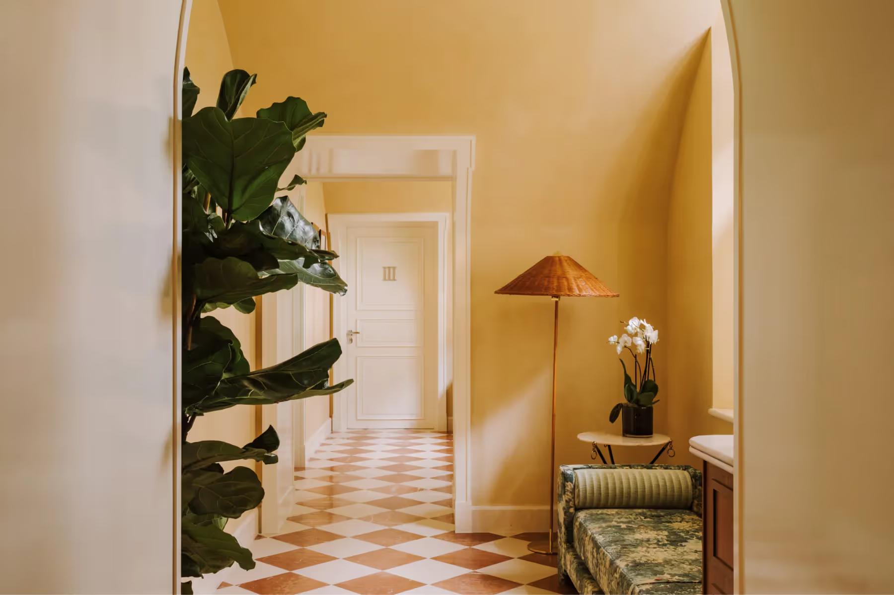 Spa treatment room with yellow ochre walls, dual vanities, and palm plant