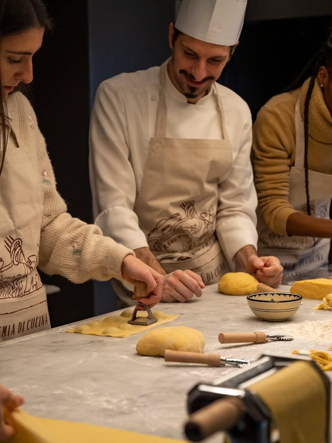 Chefs shaping fresh pasta together on a marble counter in the estate kitchen
