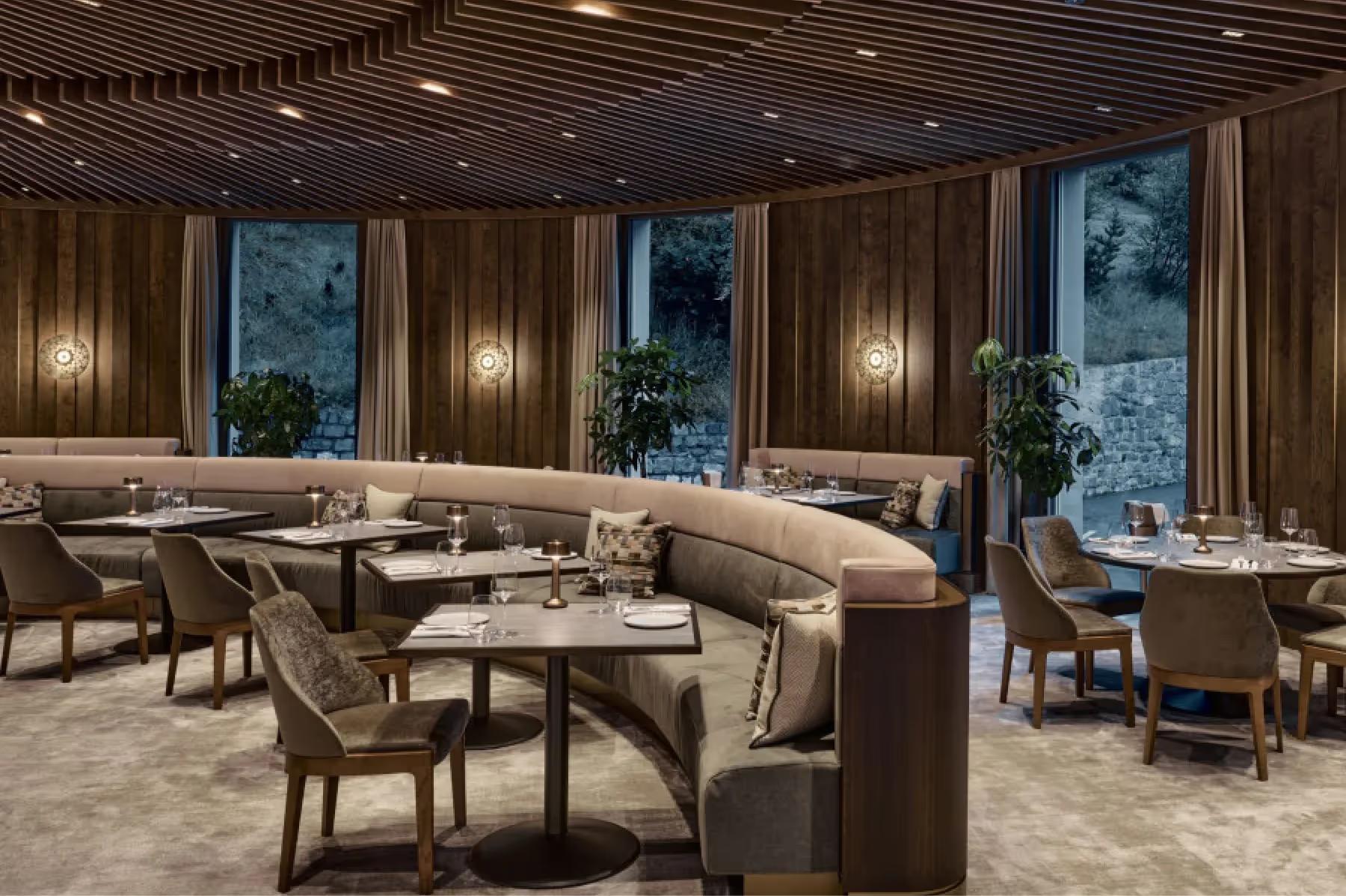 Fine dining room with wood elements, cream furnishings, soft lighting, and mountain views