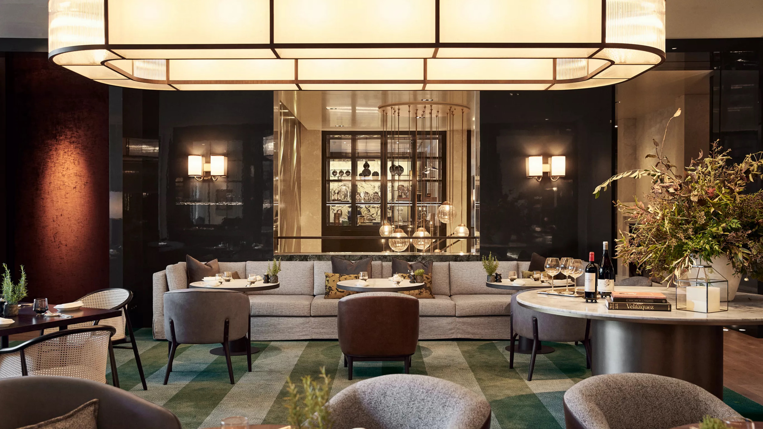 Rosewood Villa Magna: an elegant dining room with gold ceiling detail, dark walls, and formal place settings