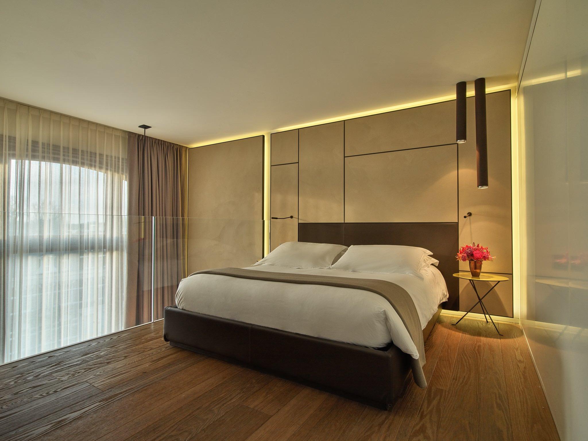 Mandarin Oriental Conservatorium, Amsterdam: master bedroom with upholstered headboard, backlit panels, and floor-to-ceiling drapes