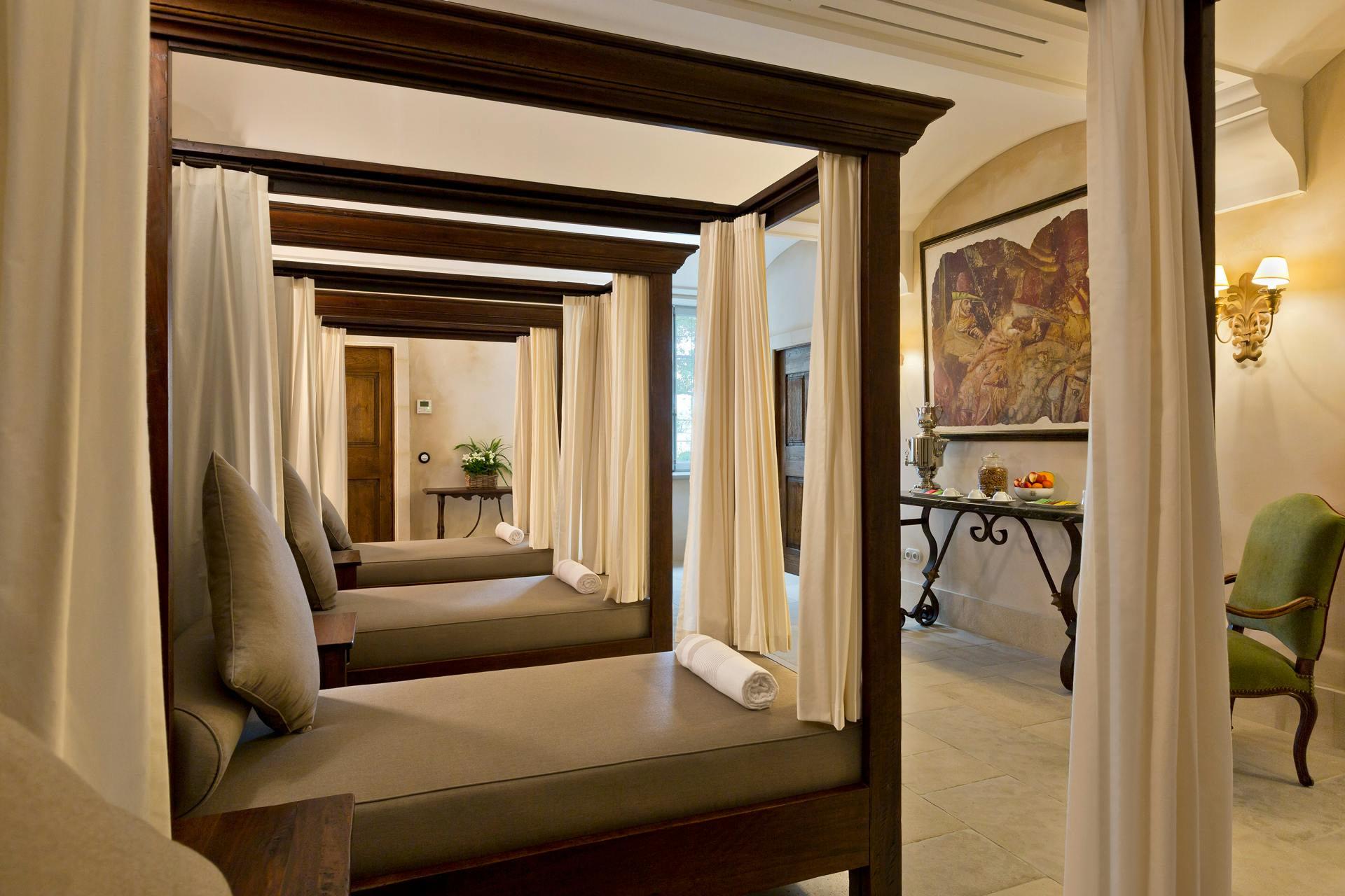 Airelles Gordes, La Bastide: arched stone colonnade with wall sconces and geometric ceiling detail