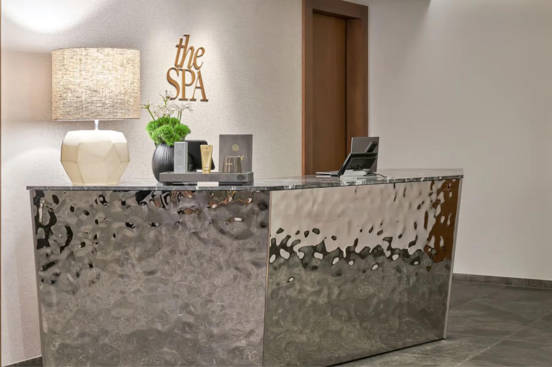 Modern reception desk with concrete finish and subtle lighting in neutral lobby space