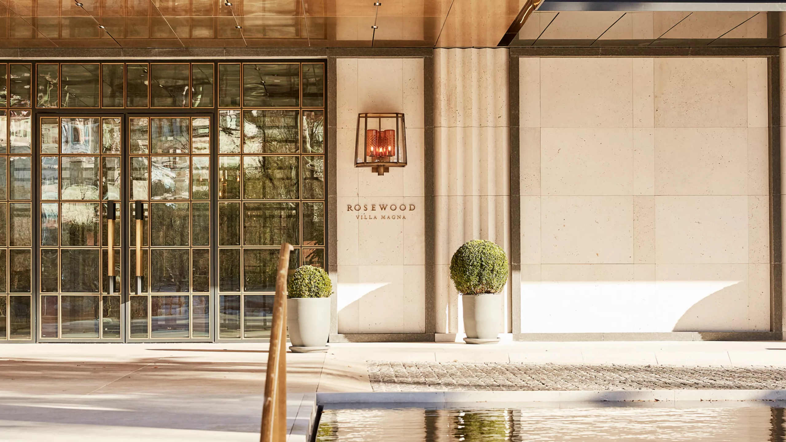The hotel entrance with glass doors, archway, and warm wood tones