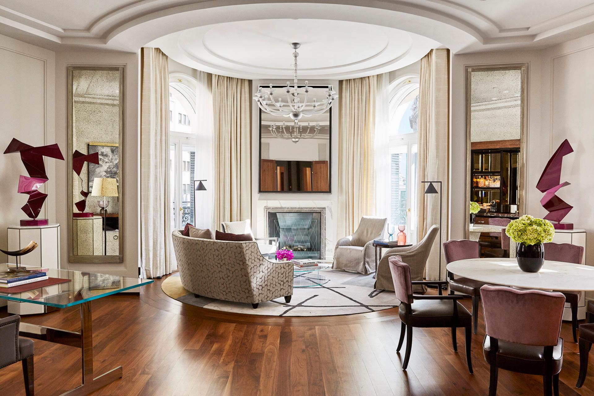 Four Seasons Hotel Madrid: suite living area with curved ceiling, burgundy accents, hardwood floors, and ornate furnishings