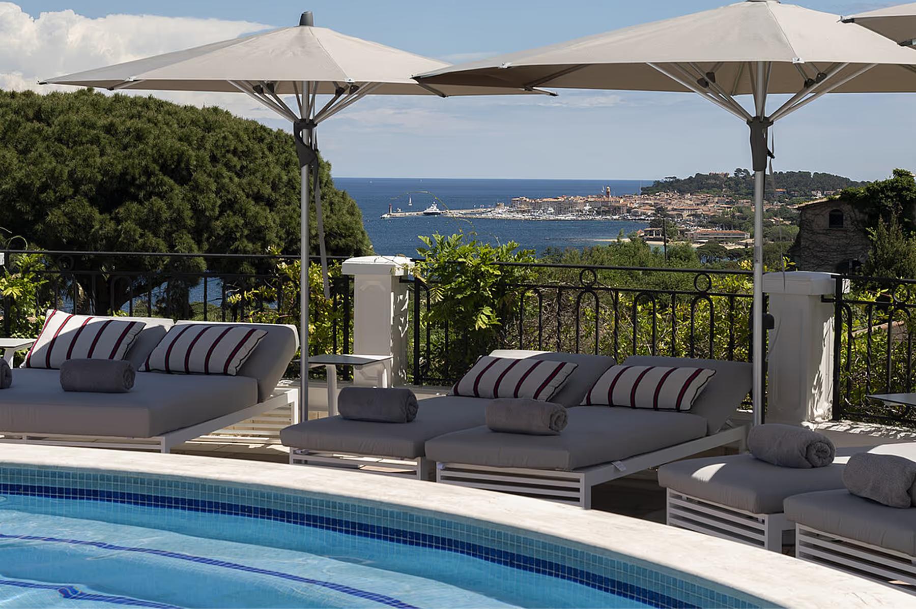 Poolside cabana terrace overlooking the coast under a cantilever shade