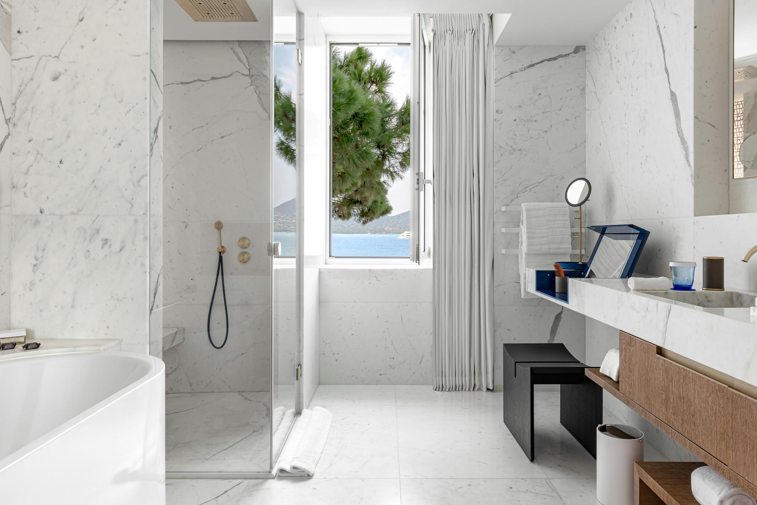 Marble bathroom with walk-in shower and coastal light