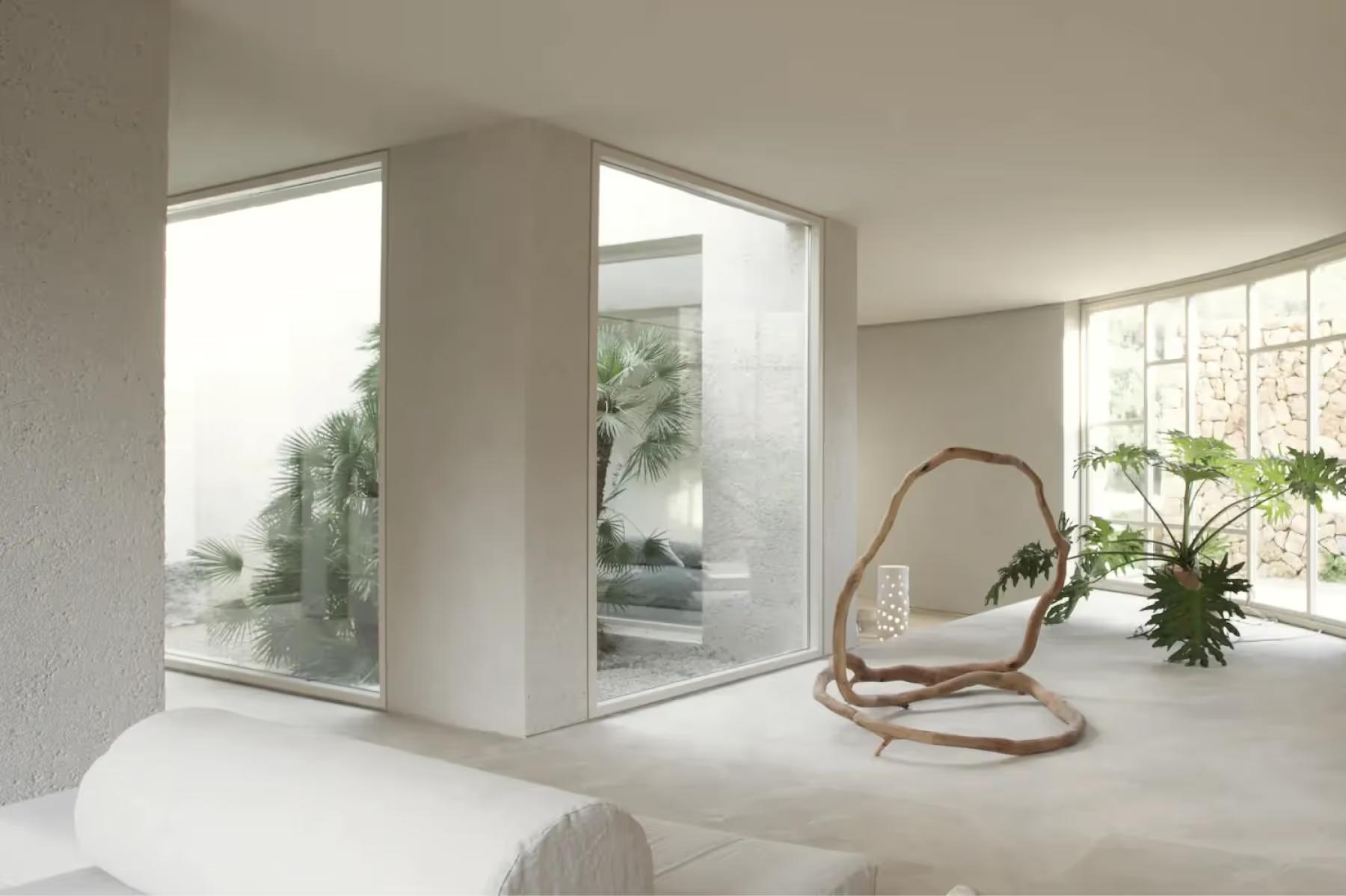 Meditation or yoga room with geometric window frame, rattan hanging chair, and potted plants