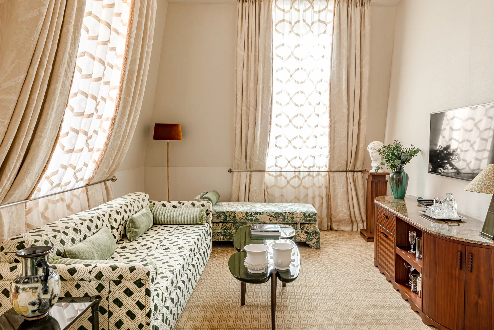 Saint James: sitting room with tall arched windows, geometric upholstered furniture, and light neutral tones