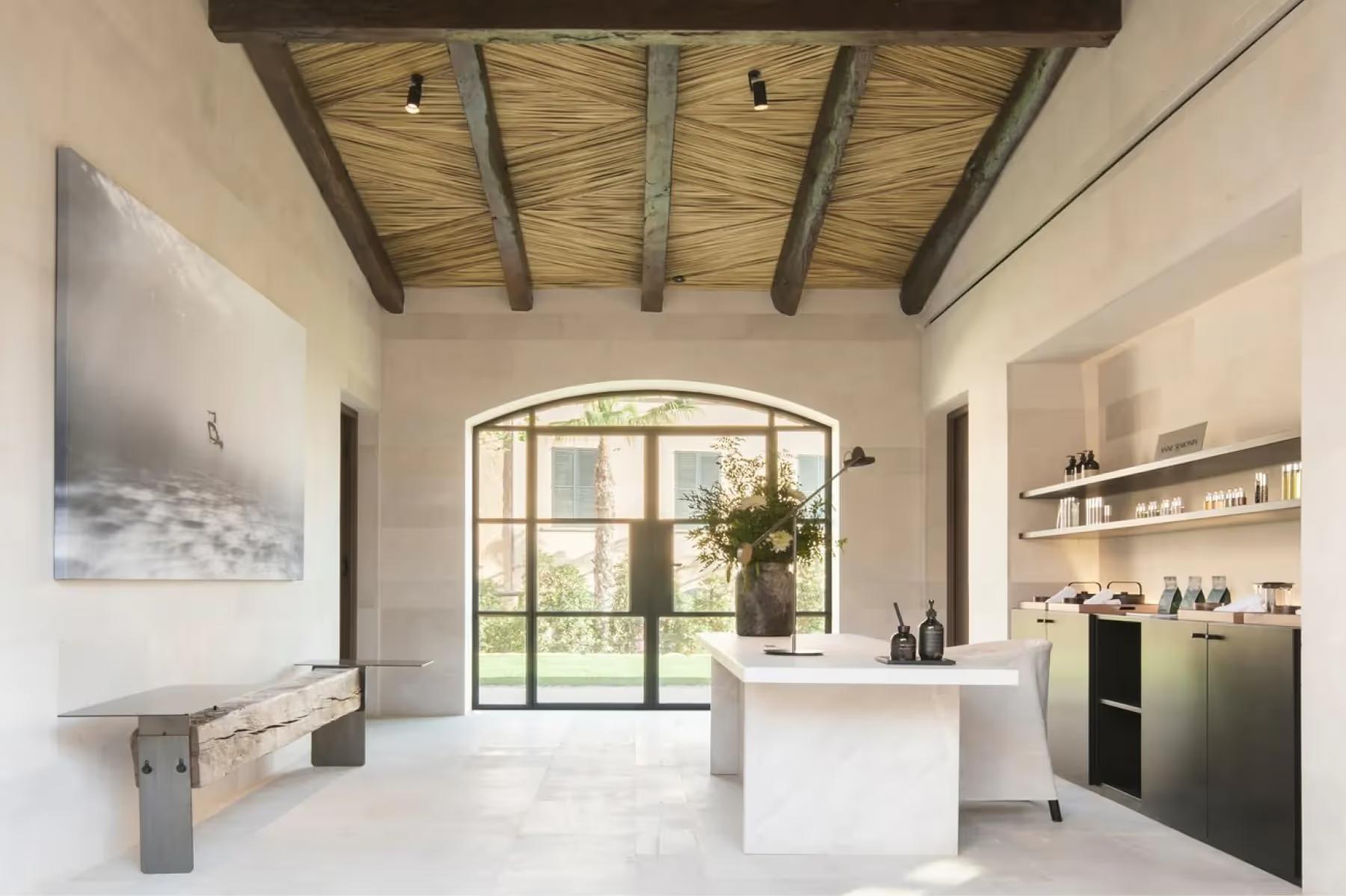 Can Ferrereta: spa reception with modern white cabinetry and wooden barrel ceiling