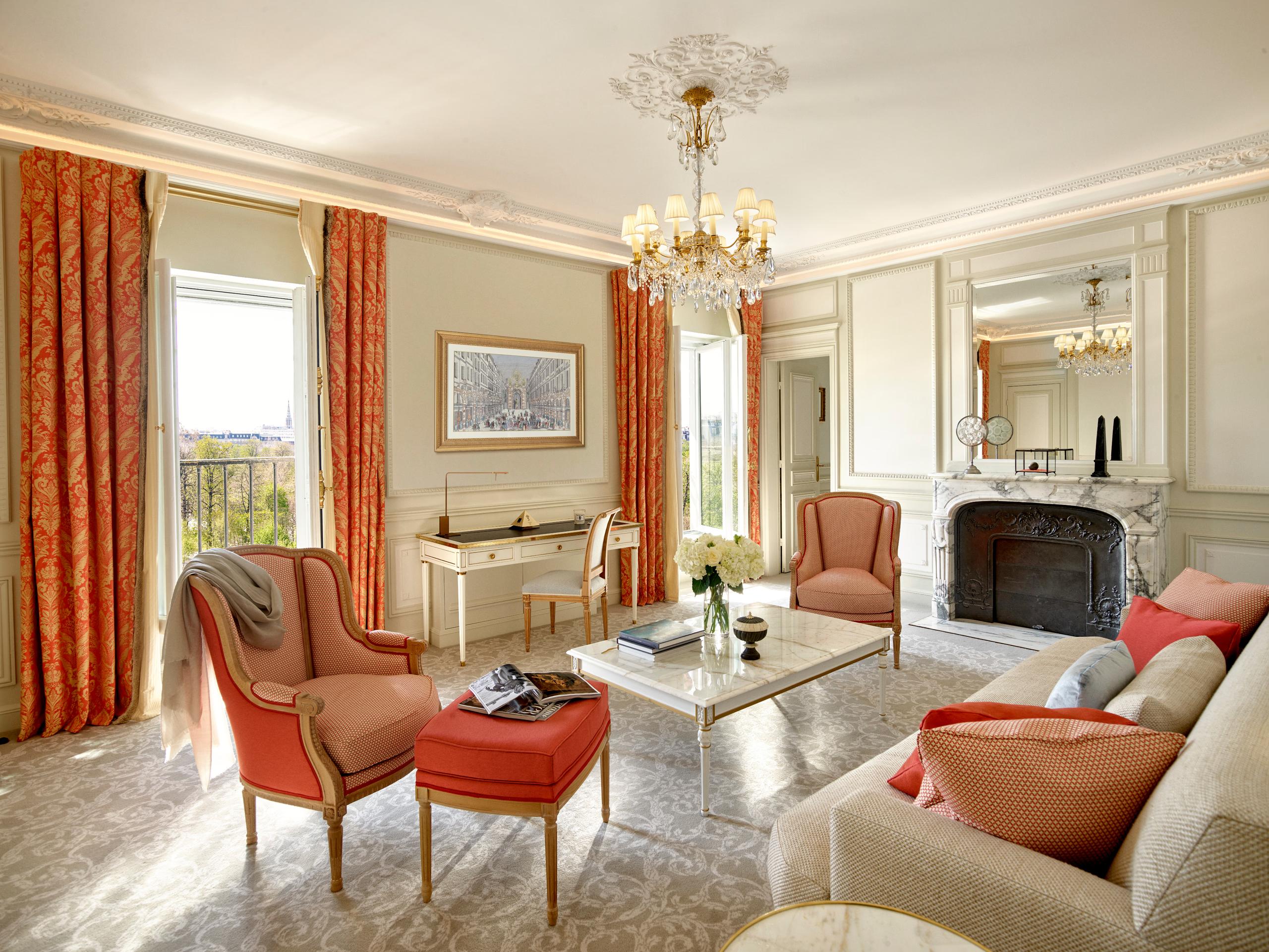 Le Meurice: a suite living room in warm tones with terracotta upholstery and classical framed artwork