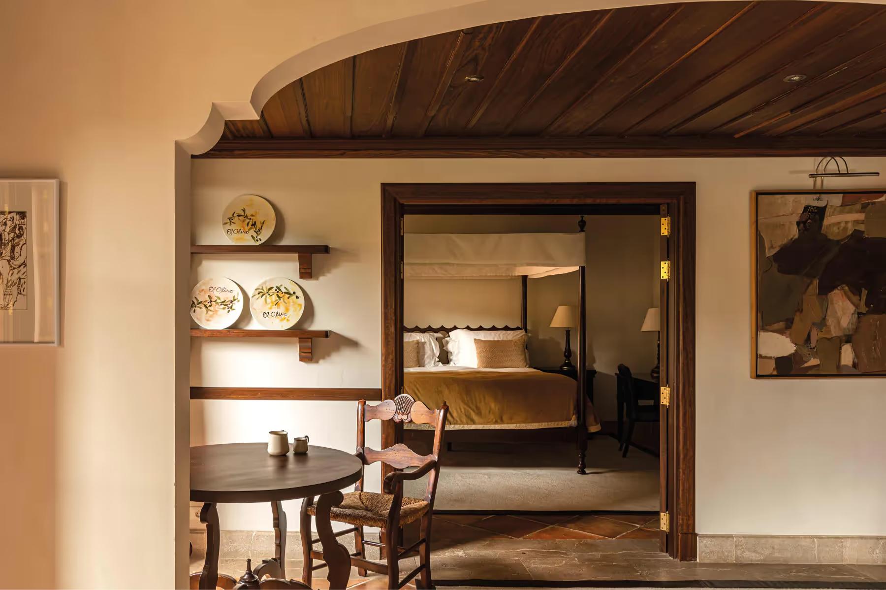 La Residencia: bedroom with vaulted wooden ceiling, mirrored wardrobe doors, and view to adjoining room
