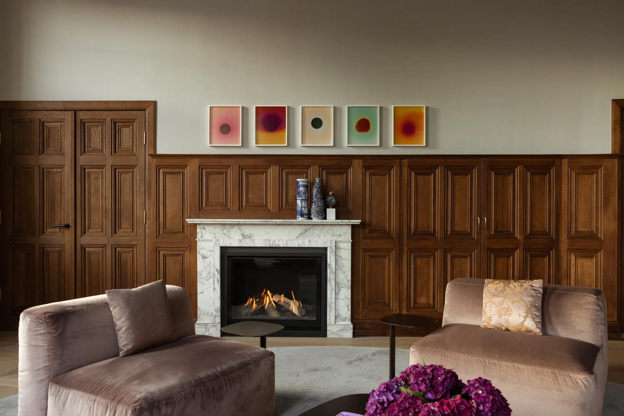 Rosewood Amsterdam: the Herengracht House with a marble fireplace, oak paneling, and velvet chairs