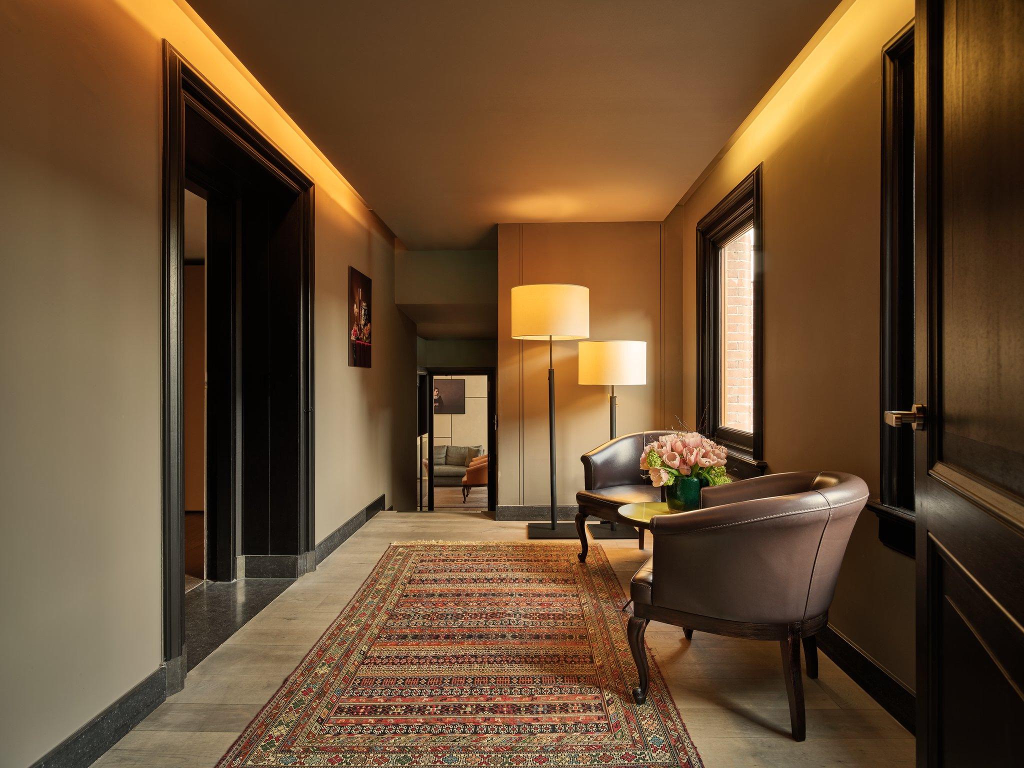 Mandarin Oriental Conservatorium, Amsterdam: foyer with patterned runner rug, dark doors, mirror wall, and contemporary furnishings