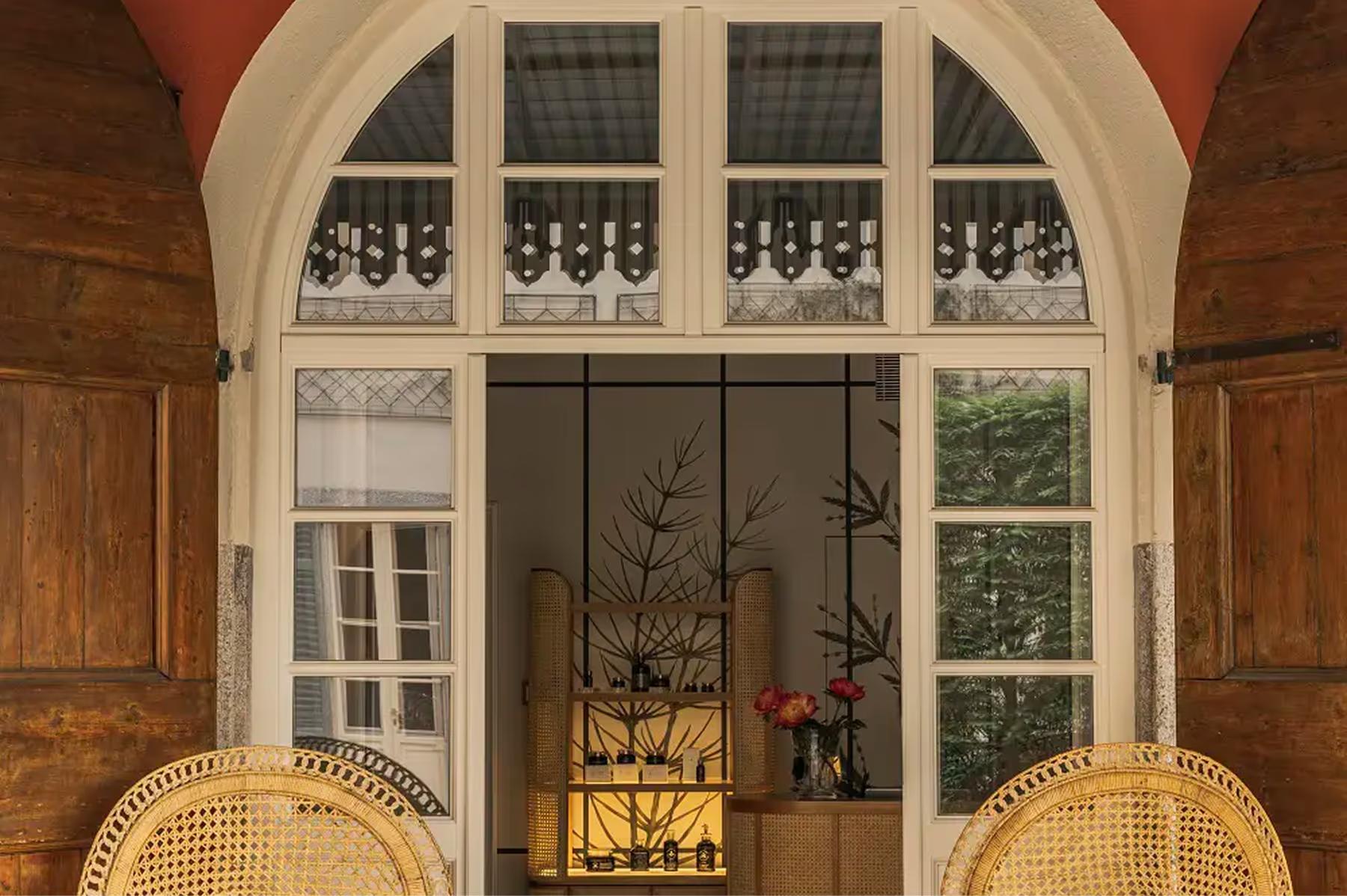 Passalacqua: an arched glass door opening to green grounds and distant lake landscape