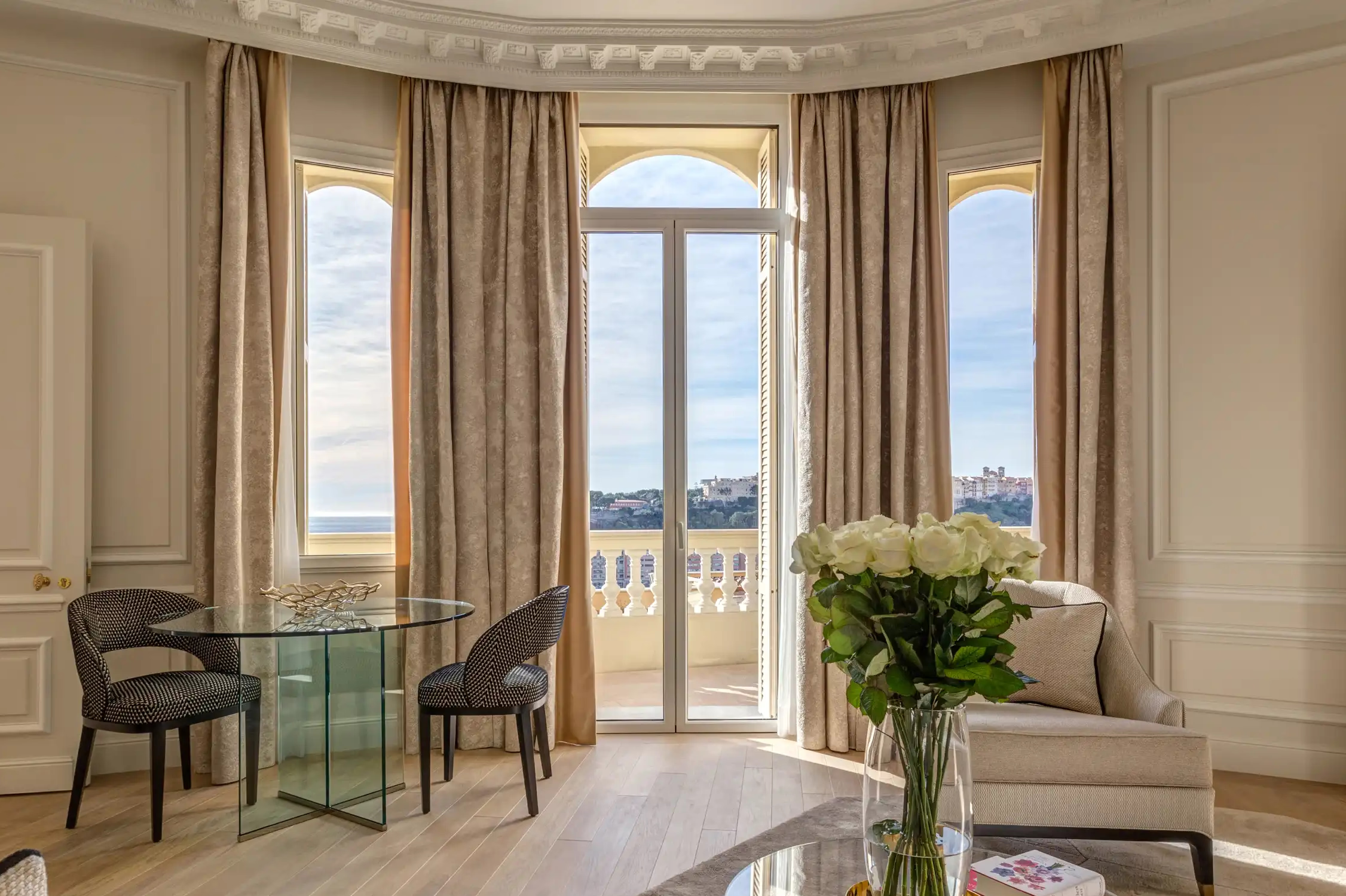 Hôtel Hermitage Monte-Carlo: sitting area with arched glass doors opening to Mediterranean panorama, neutral tone furniture