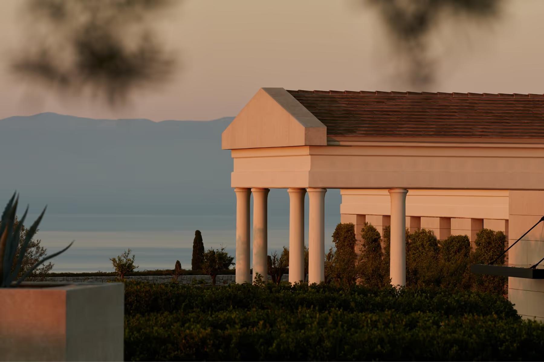 Amanzoe: waterfront terrace at dusk with fire feature and sea view