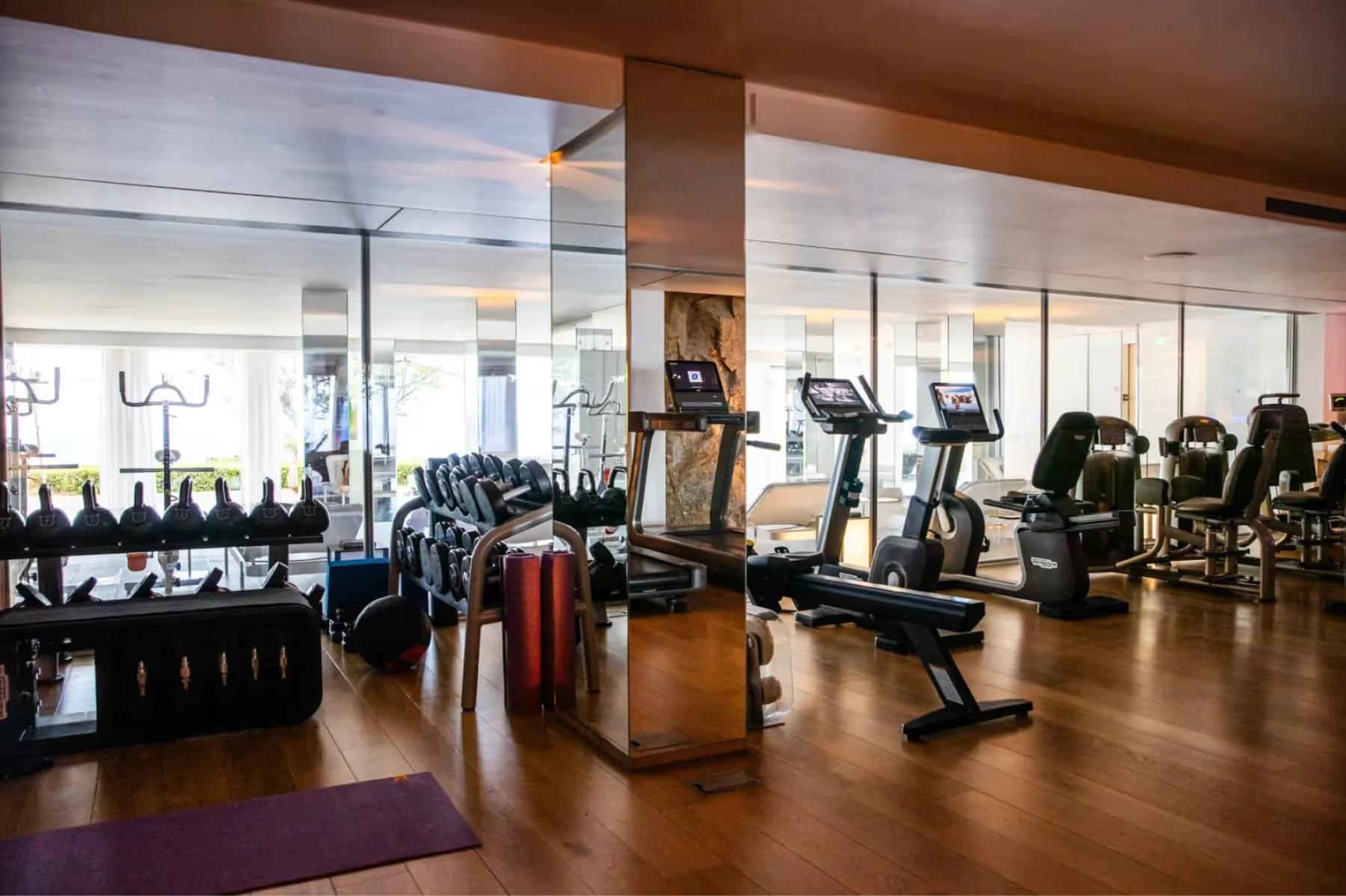 La Réserve Ramatuelle: fitness center with cardio equipment and wall of windows