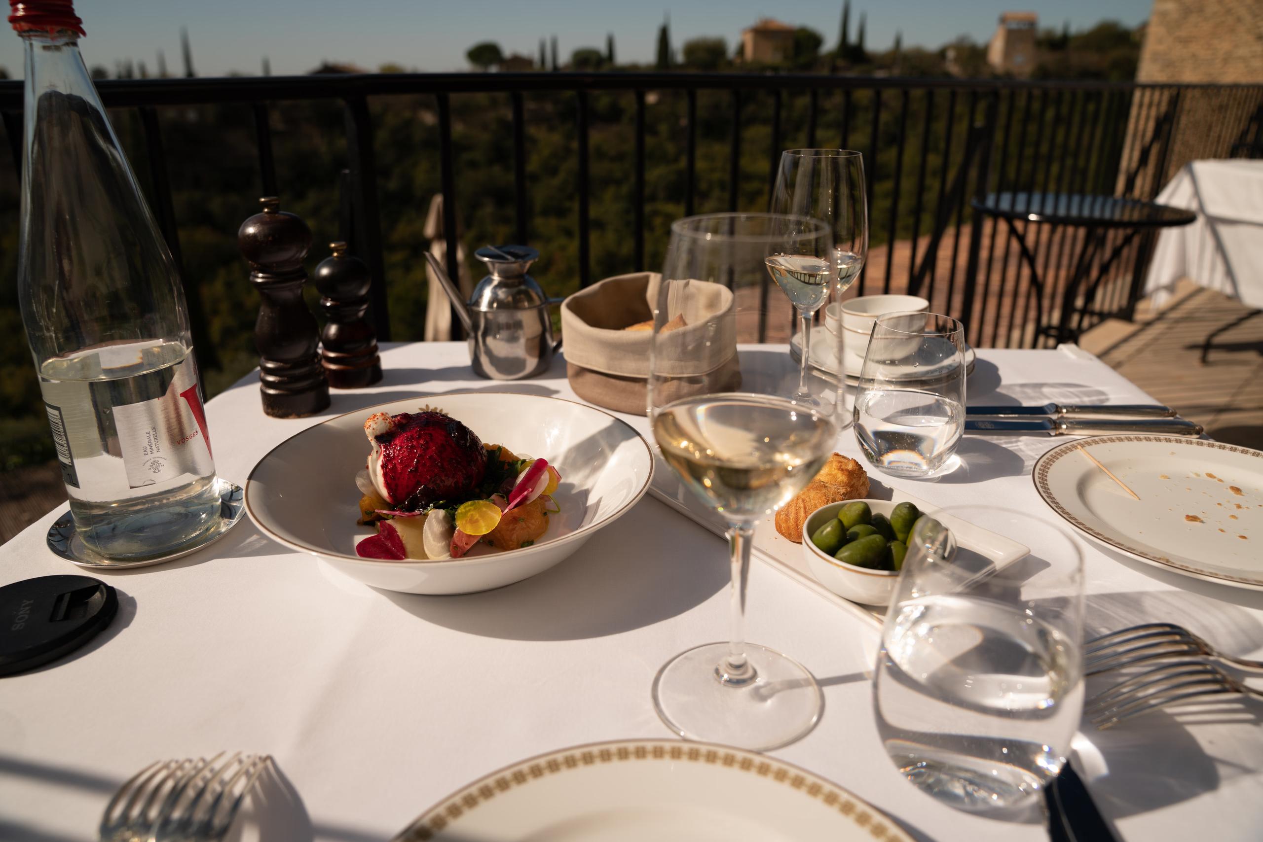 Airelles Gordes, La Bastide: formal place setting with wine glass and water glass on white tablecloth