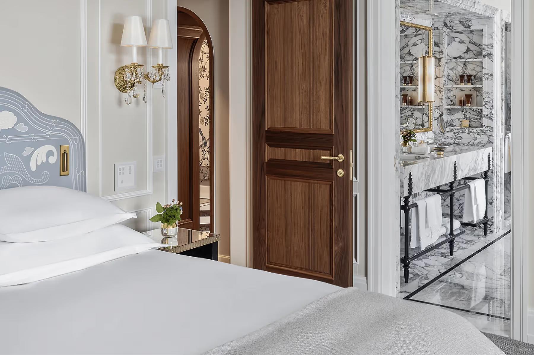 Hallway with white walls, wooden doors, and light stone flooring