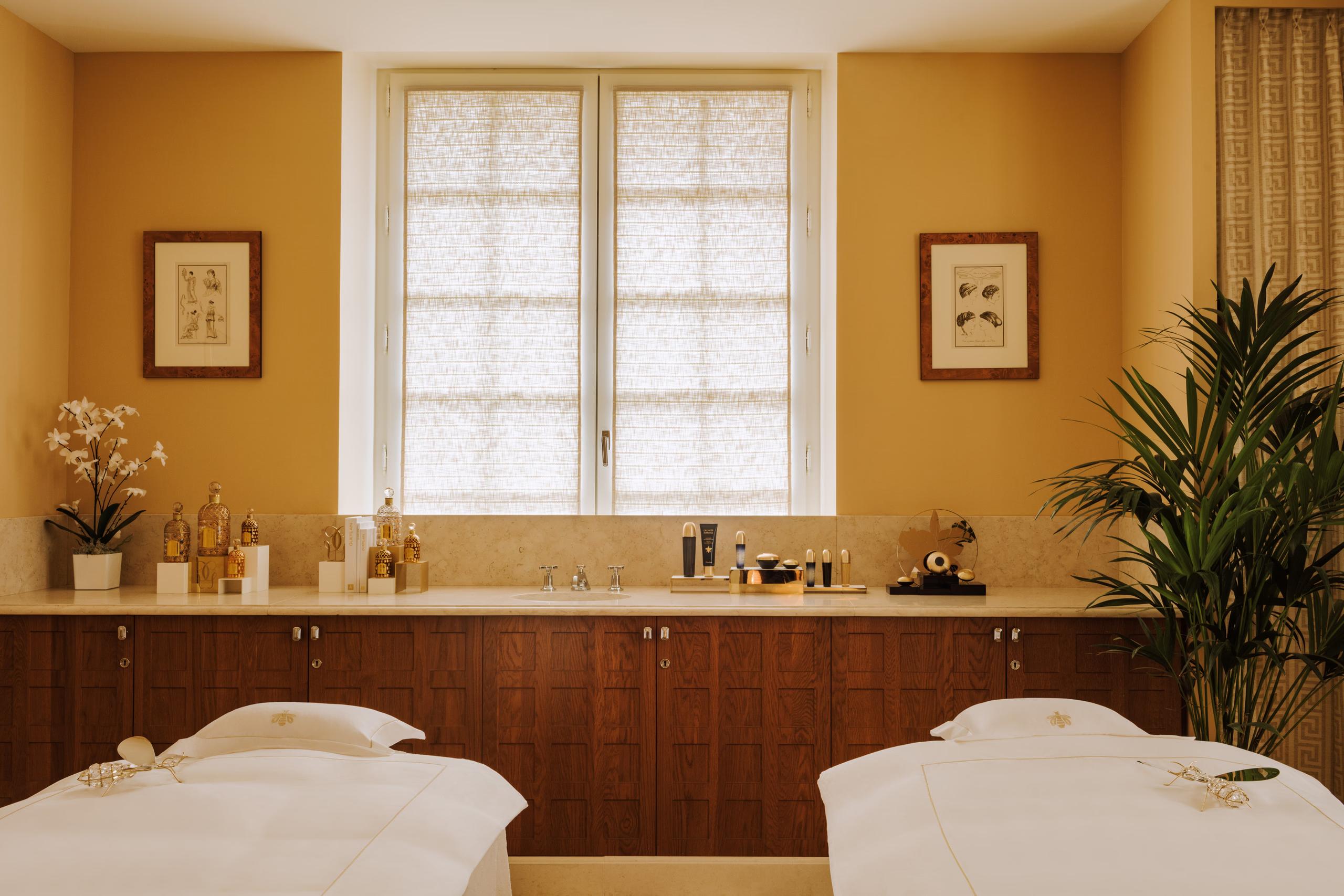 Spa room with black tile, wood cabinetry, and brass fixtures