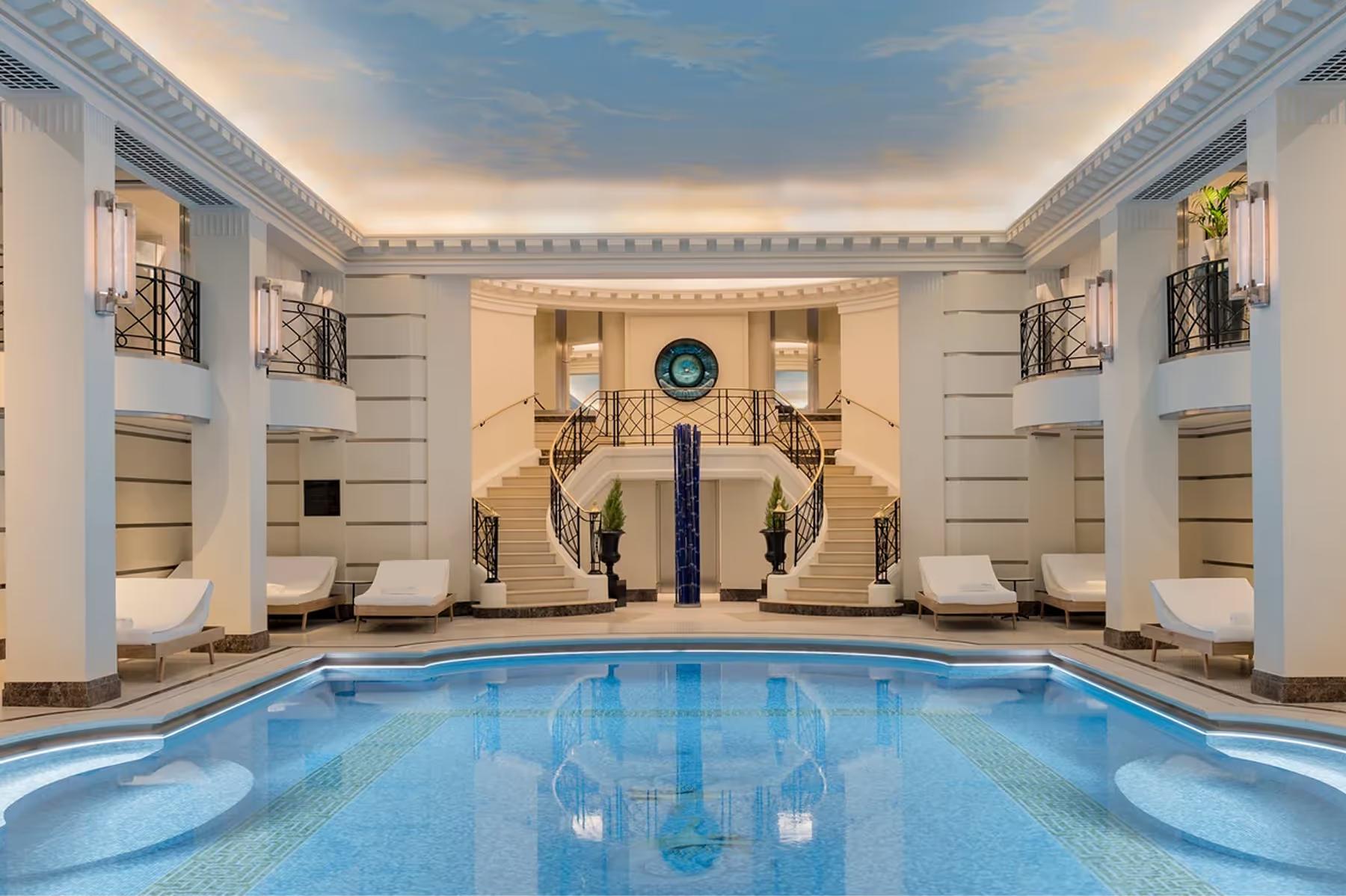 Ritz Paris: the indoor swimming pool with pale stone walls, arched alcoves, and recessed lighting