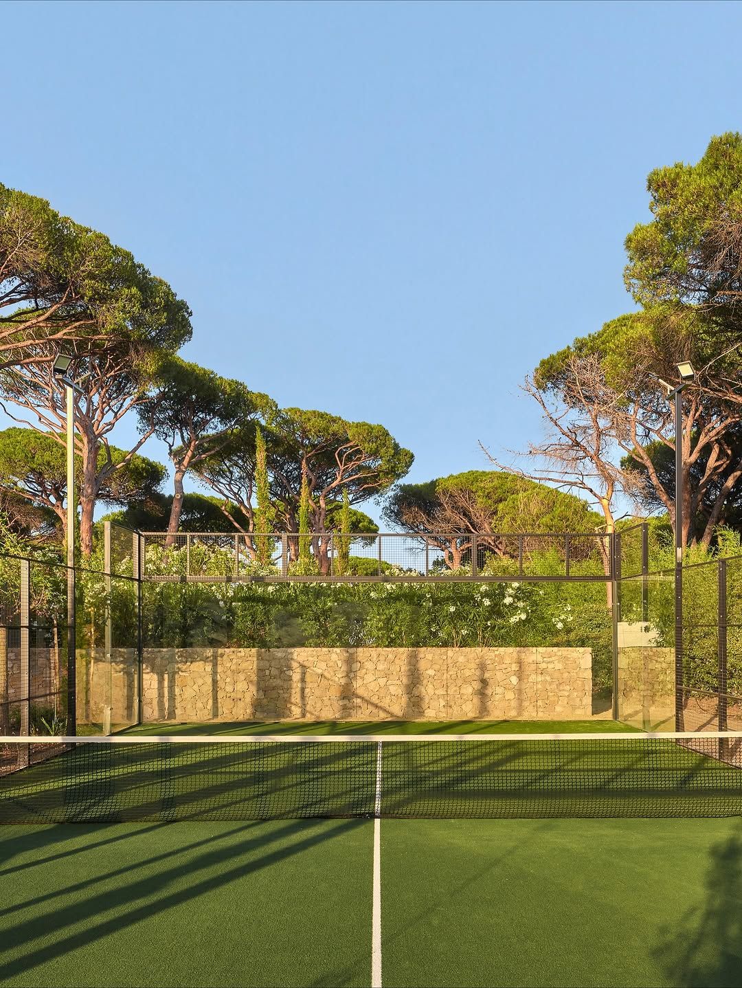 A sunken tennis court among umbrella pines at Château de la Messardière