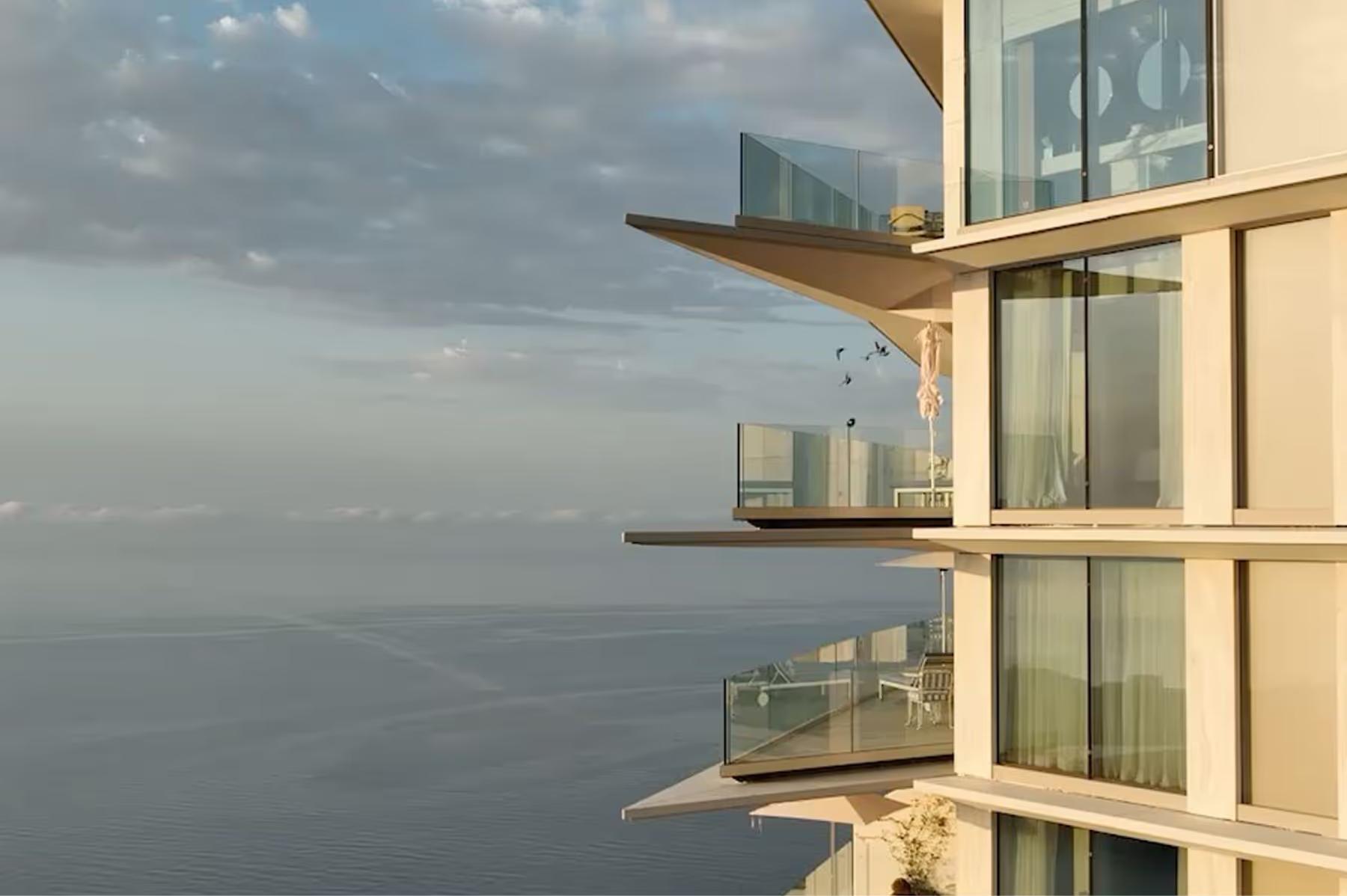 Stacked terraces and glass balconies above sea
